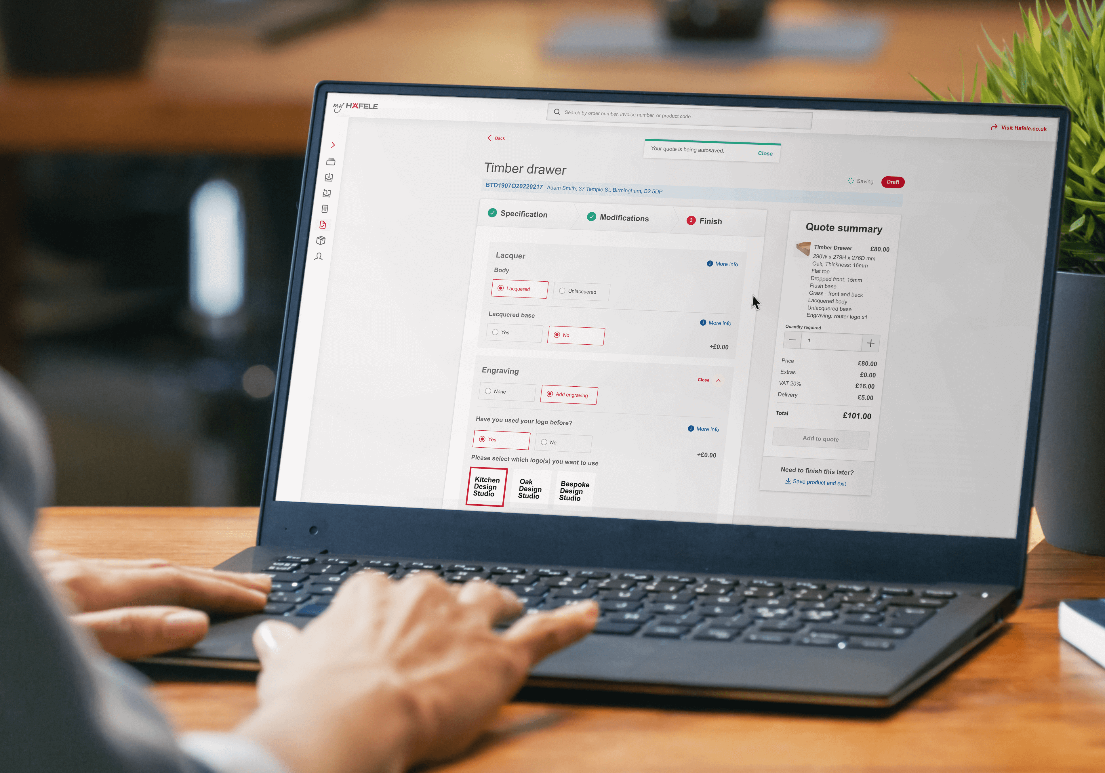 A user browsing through the Hafele quoting summary window page on a black laptop sitting on a wooden desk