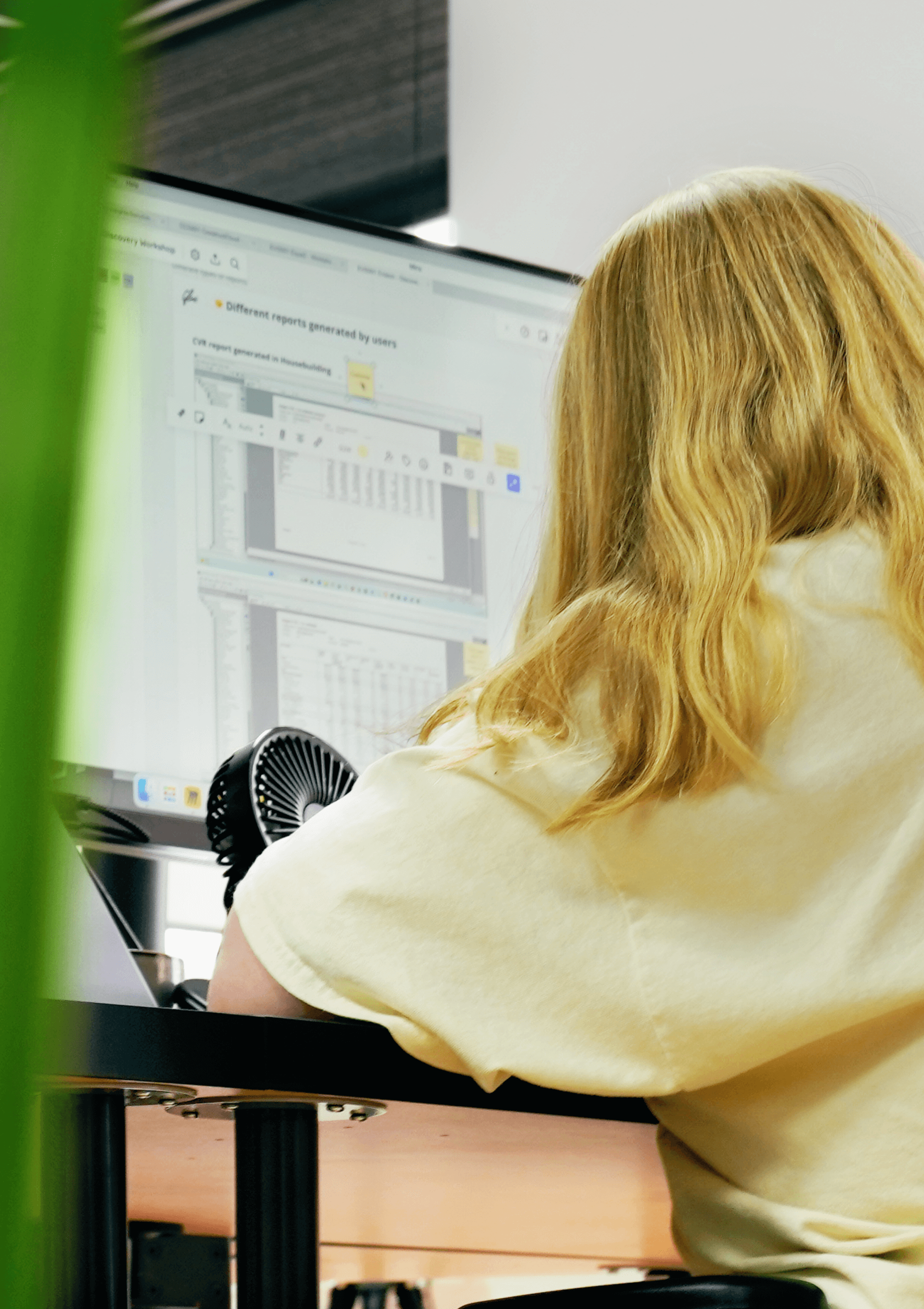 A female researcher sits at her computer reviewing notes from a user interview