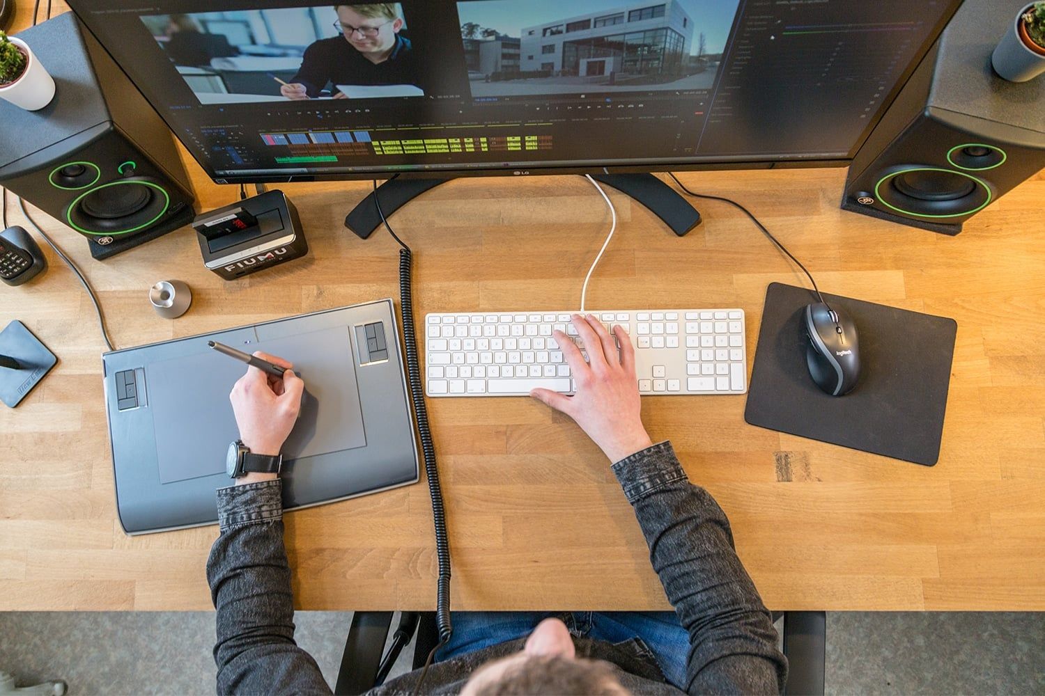 Editor arbeitet in der FIUMU-Postproduktion mit Grafiktablett und Schnittsoftware am Monitor