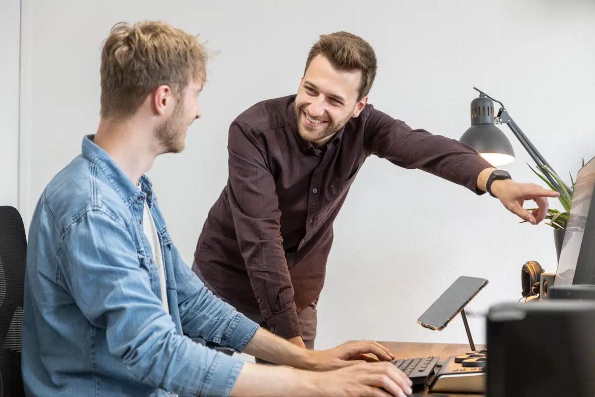 Zwei FIUMU-Kollegen besprechen ein Projekt am Arbeitsplatz