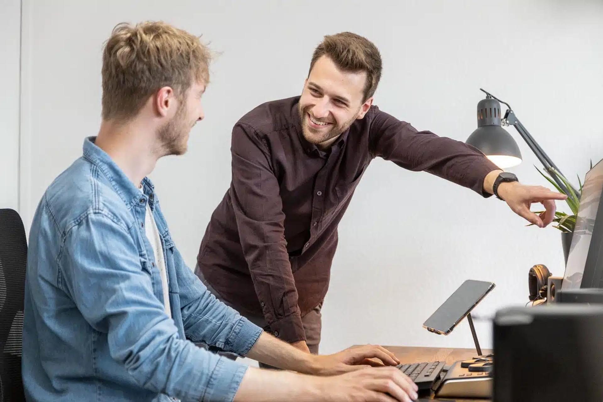 Zwei FIUMU-Kollegen besprechen einen Entwurf am Bildschirm