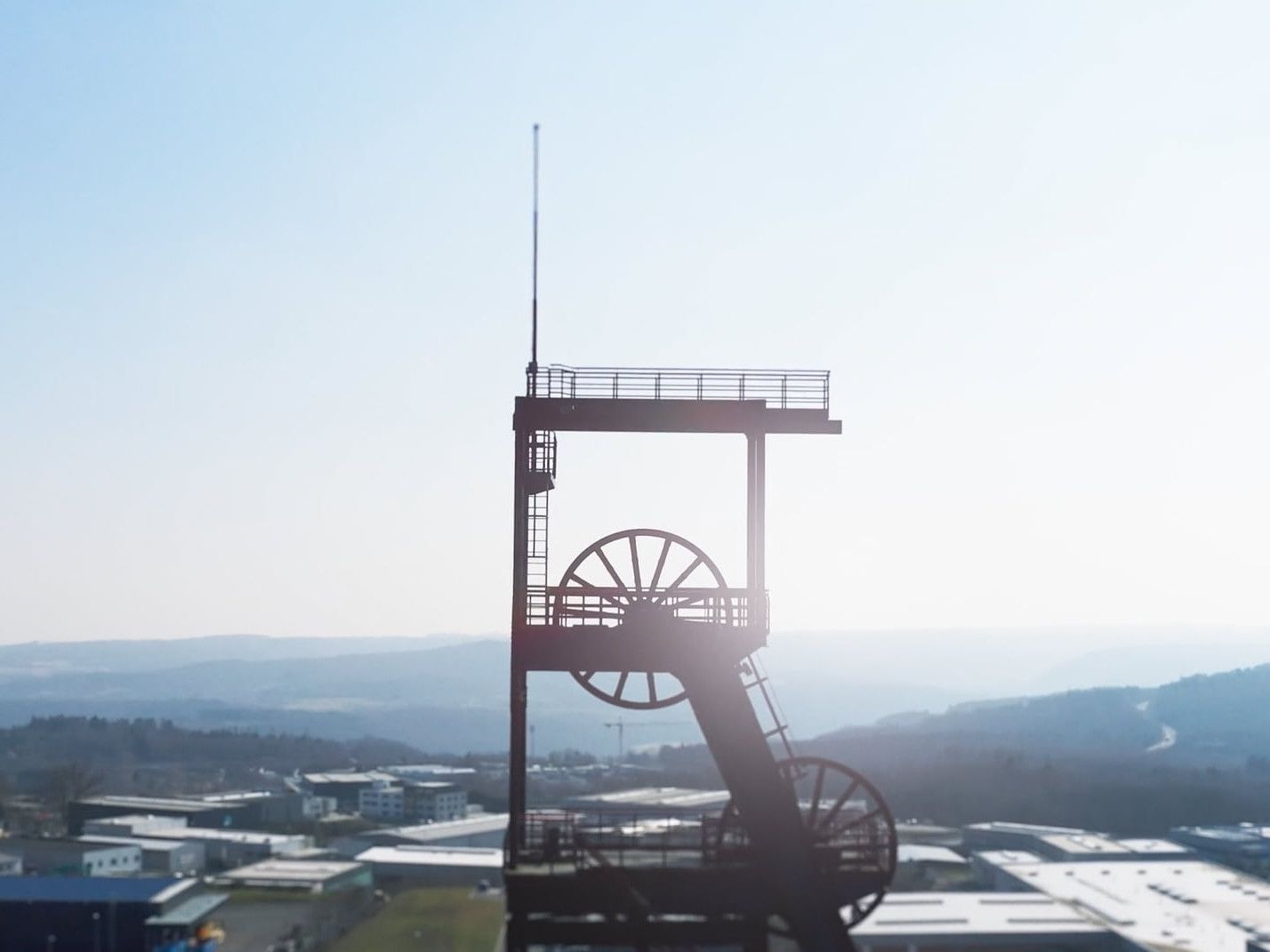 Förderturm einer Zeche im Gegenlicht über einem Gewerbegebiet – Motiv aus einem Unternehmensfilm