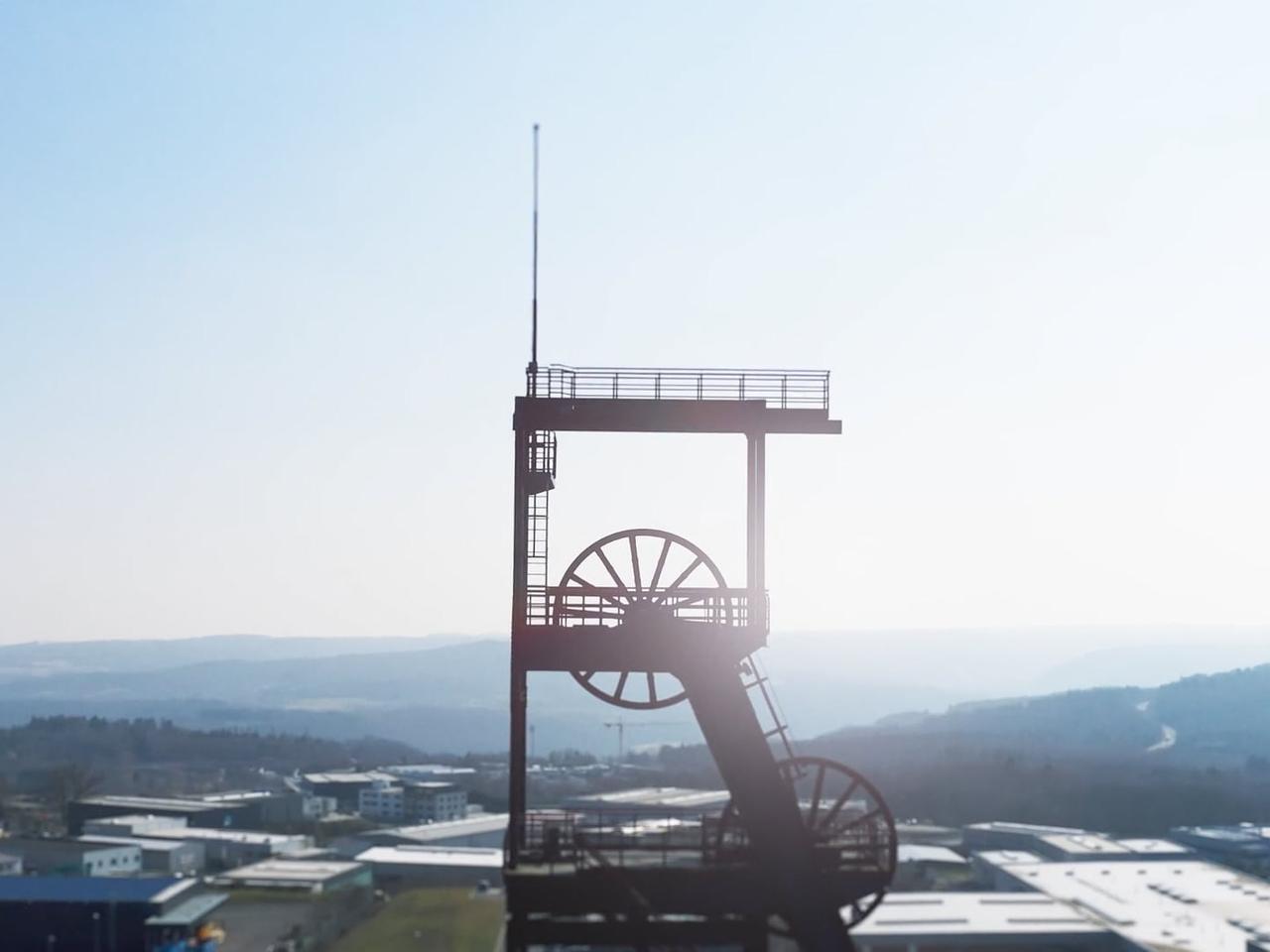 Förderturm einer Zeche im Gegenlicht über einem Gewerbegebiet – Motiv aus einem Unternehmensfilm