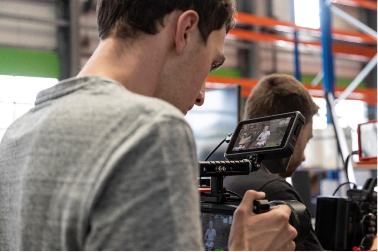 FIUMU-Kameramann filmt mit Schulterkamera während der Dreharbeiten zu einem Eventfilm in einer Halle