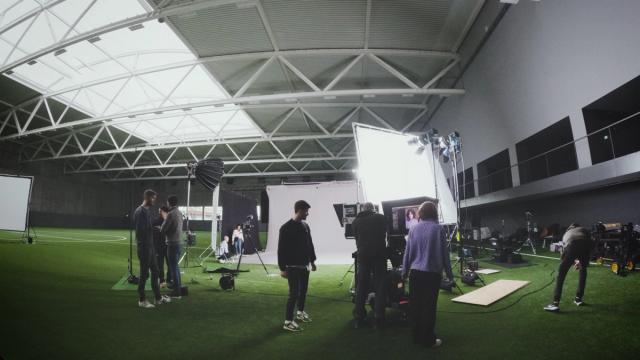 Filmcrew beim Set-Aufbau in einer Sporthalle