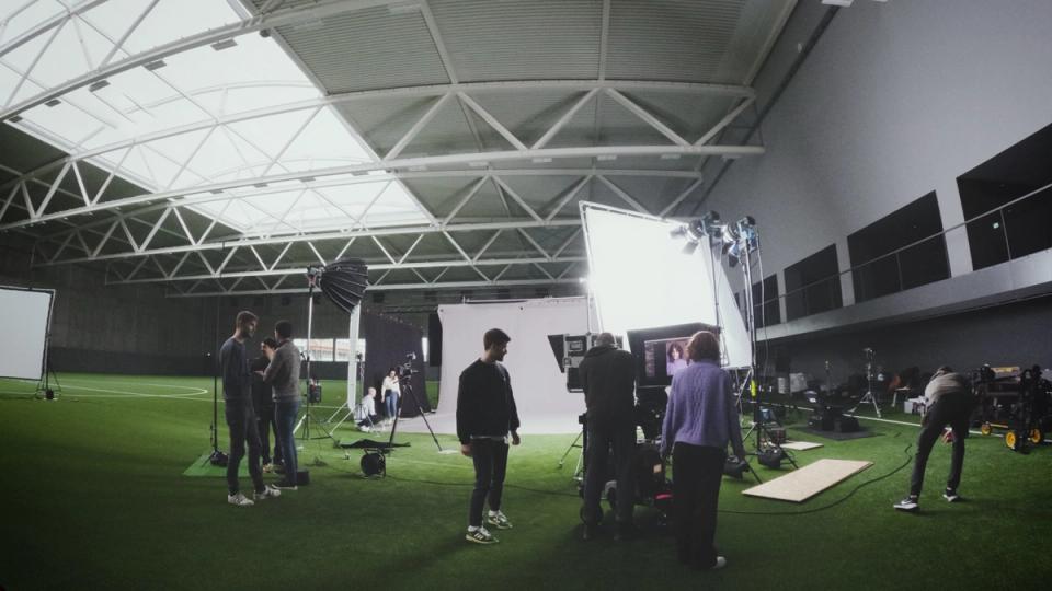 Filmcrew beim Set-Aufbau in einer Sporthalle