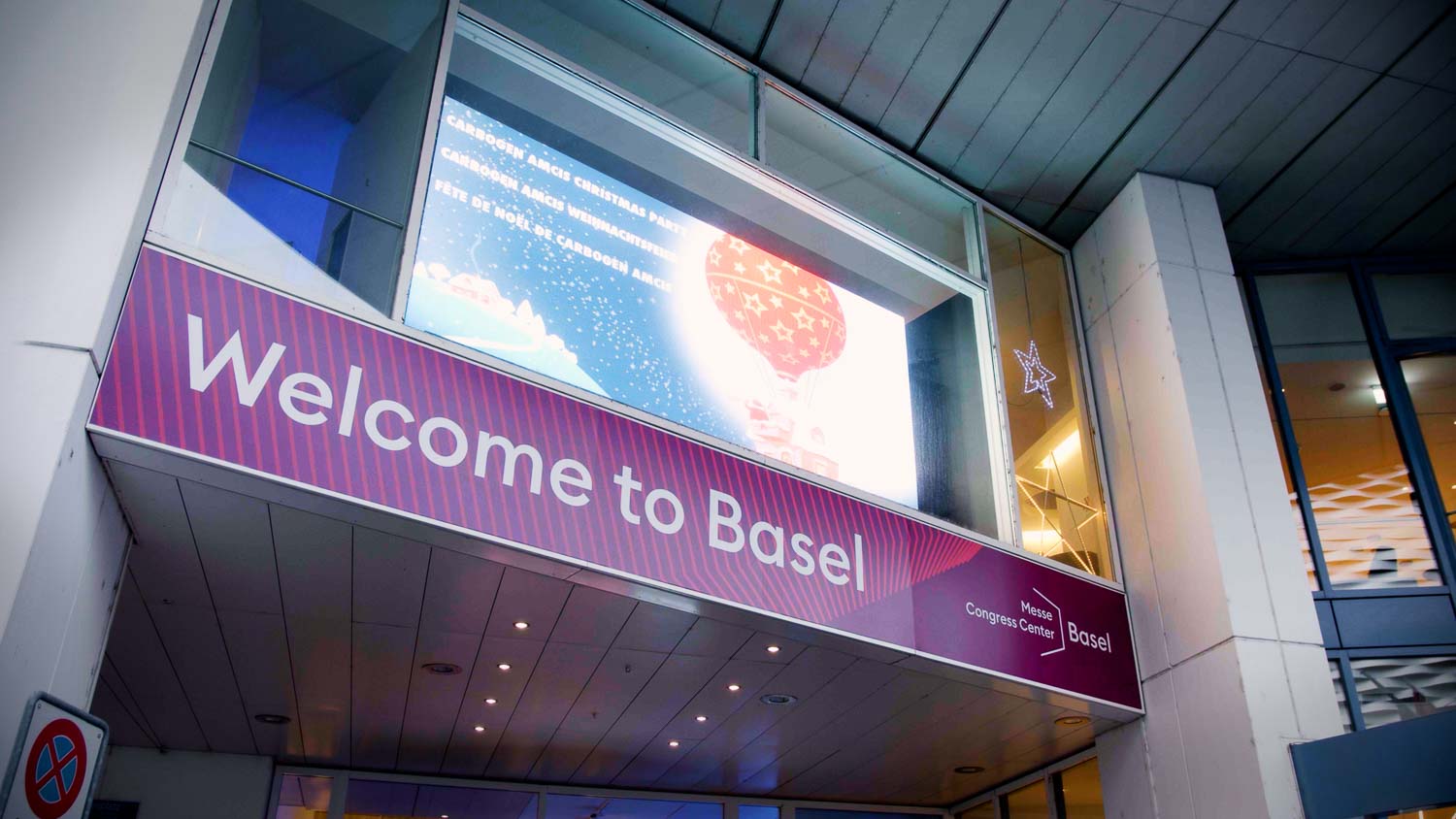 Beleuchtetes Welcome-to-Basel-Banner am Eingang des Messe Congress Center zur Carbogen-Amcis-Weihnachtsfeier im Eventfilm