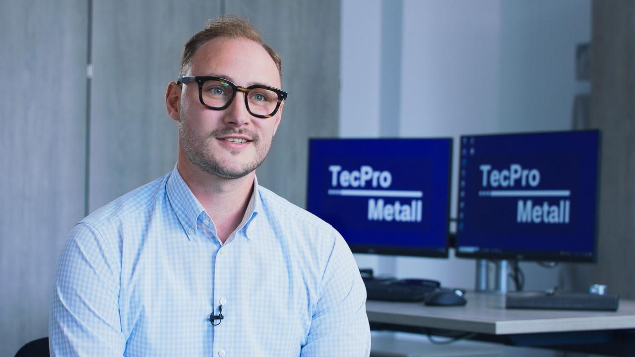 Interviewpartner mit Brille erzählt vor TecPro-Metall-Monitoren seine Geschichte in der Video-Case-Study