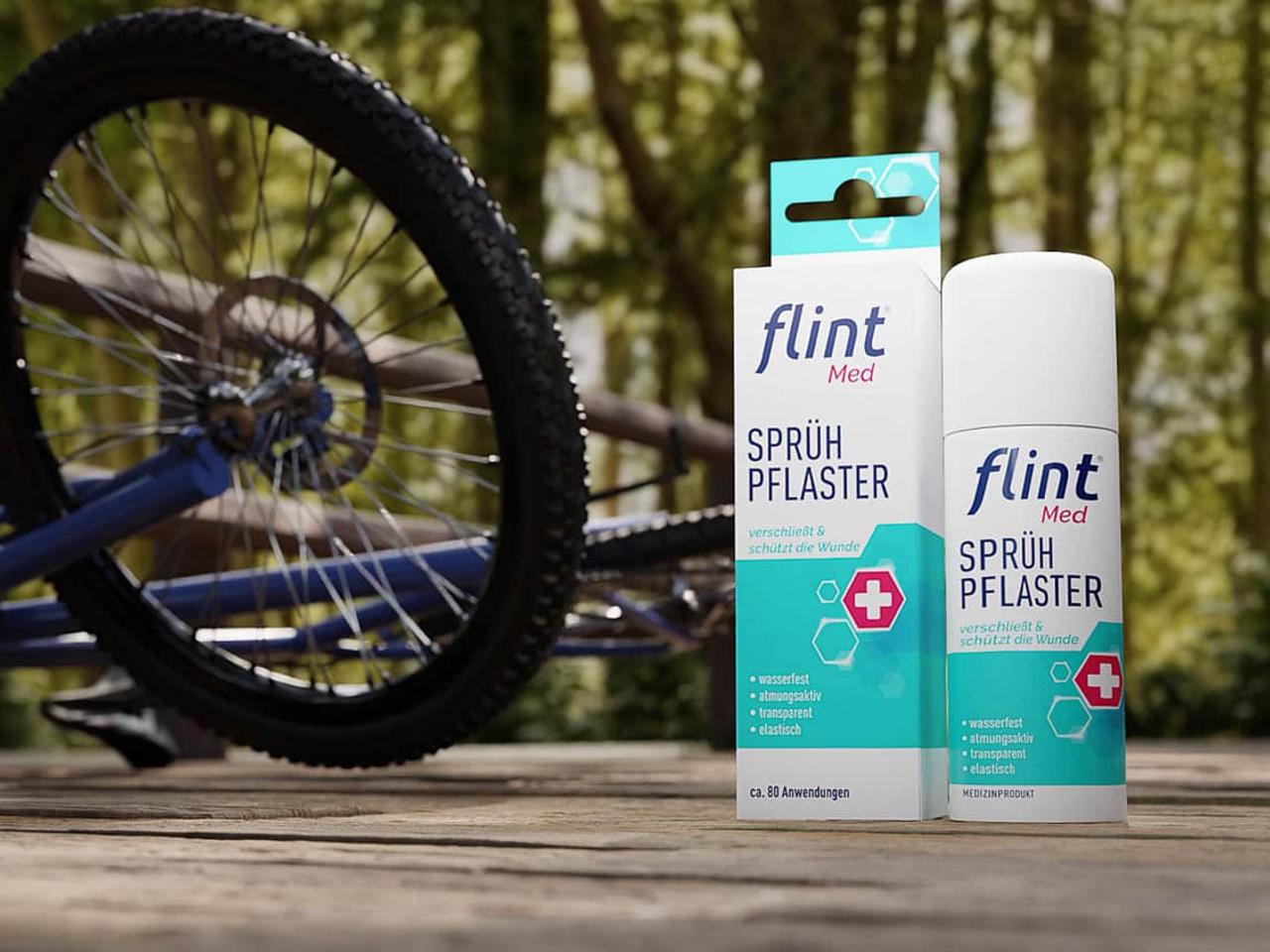 Still aus dem Flintmed-Werbefilm: Verpackung des flint Med Sprühpflasters neben einem Fahrradreifen