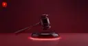 Glossy 3D judge's gavel with a glowing base on a dark crimson background — symbolizing the court ruling on xAI's lawsuit