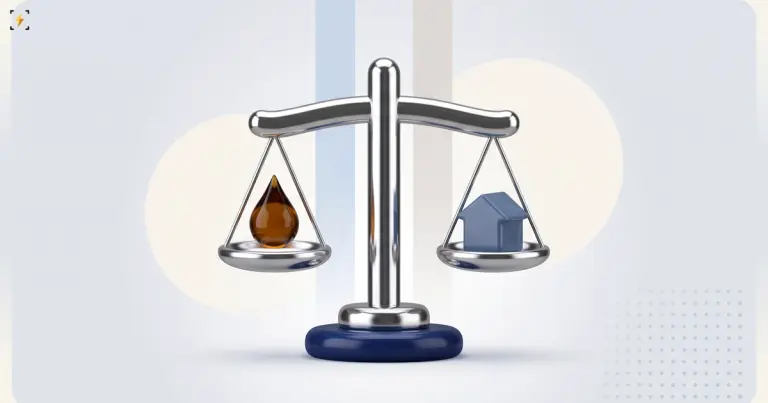 Balance scale hanging dead level with an oil drop on one pan and a small house on the other