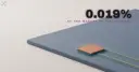 A huge blank slate-blue slab with one tiny glowing terracotta tile set into its corner
