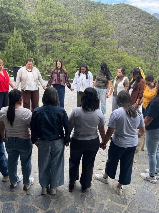 Esposas de plantadores orando en círculo en el retiro de Parakaleo