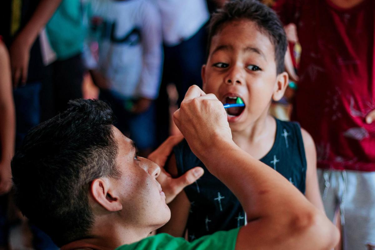 Un dentista voluntario atiende a un niño en Lima