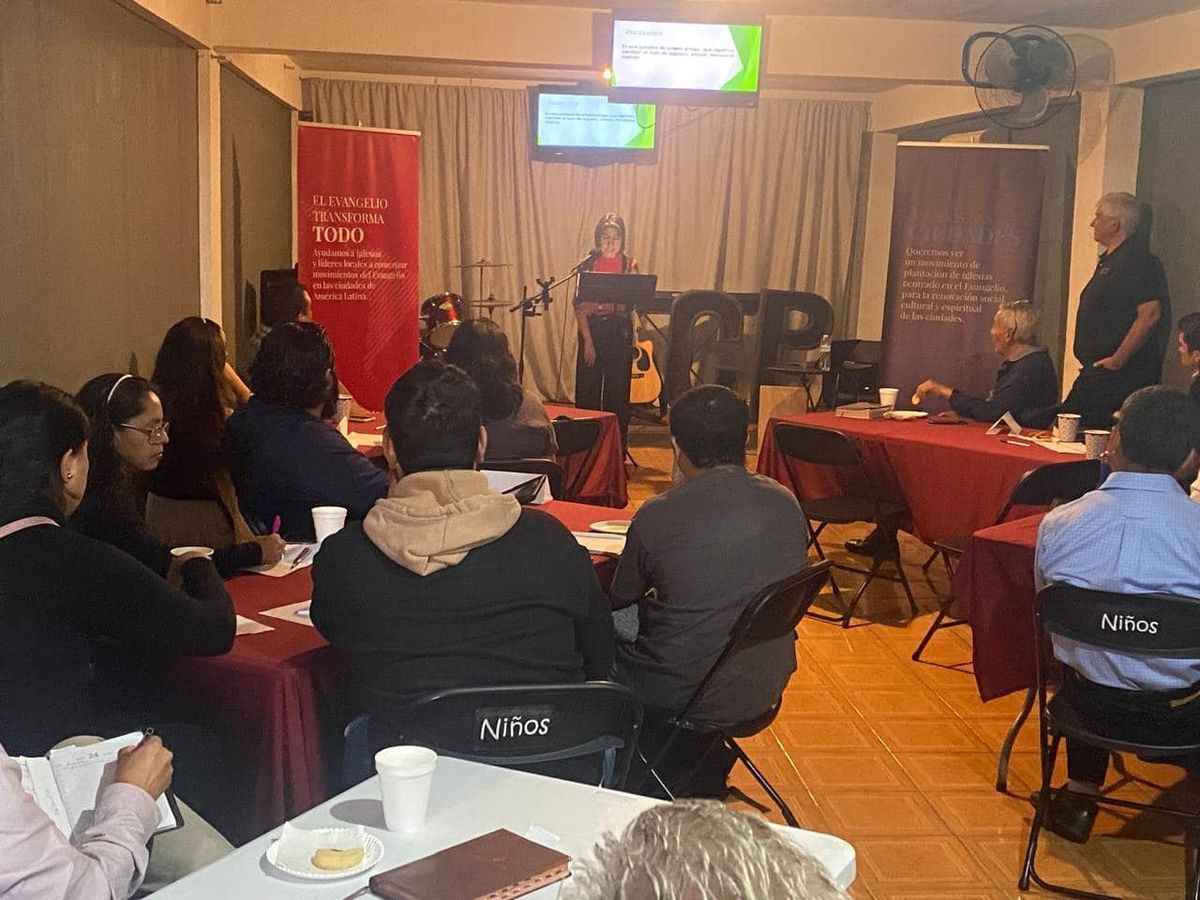 Edición local de El Evangelio en la Ciudad, con los asistentes en mesas de trabajo