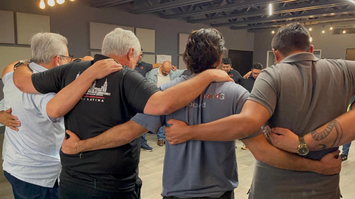 Líderes orando en círculo durante el Intensivo Internacional