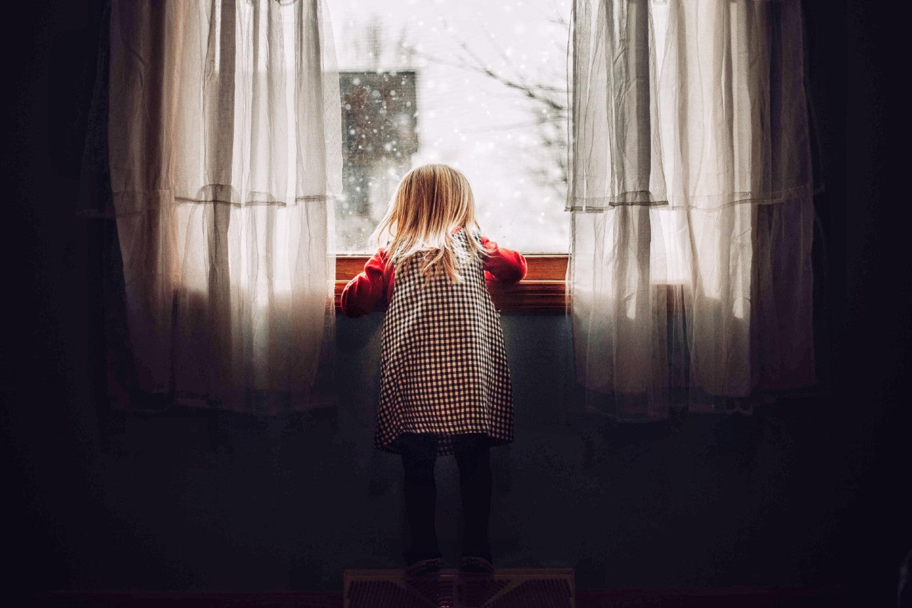 Holiday Covid isolation - little girl staring out a window