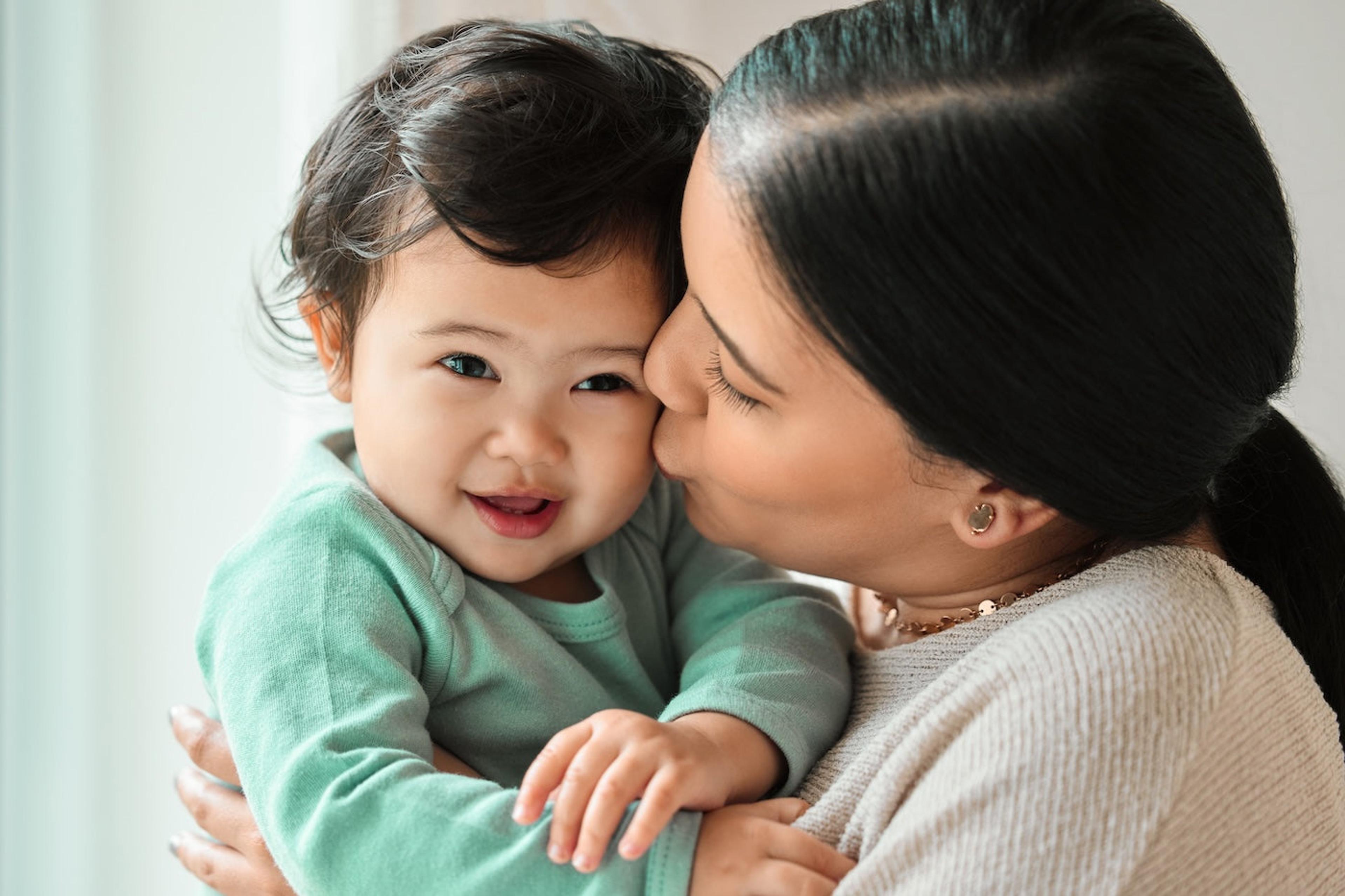 Mom kisses baby boy's cheek