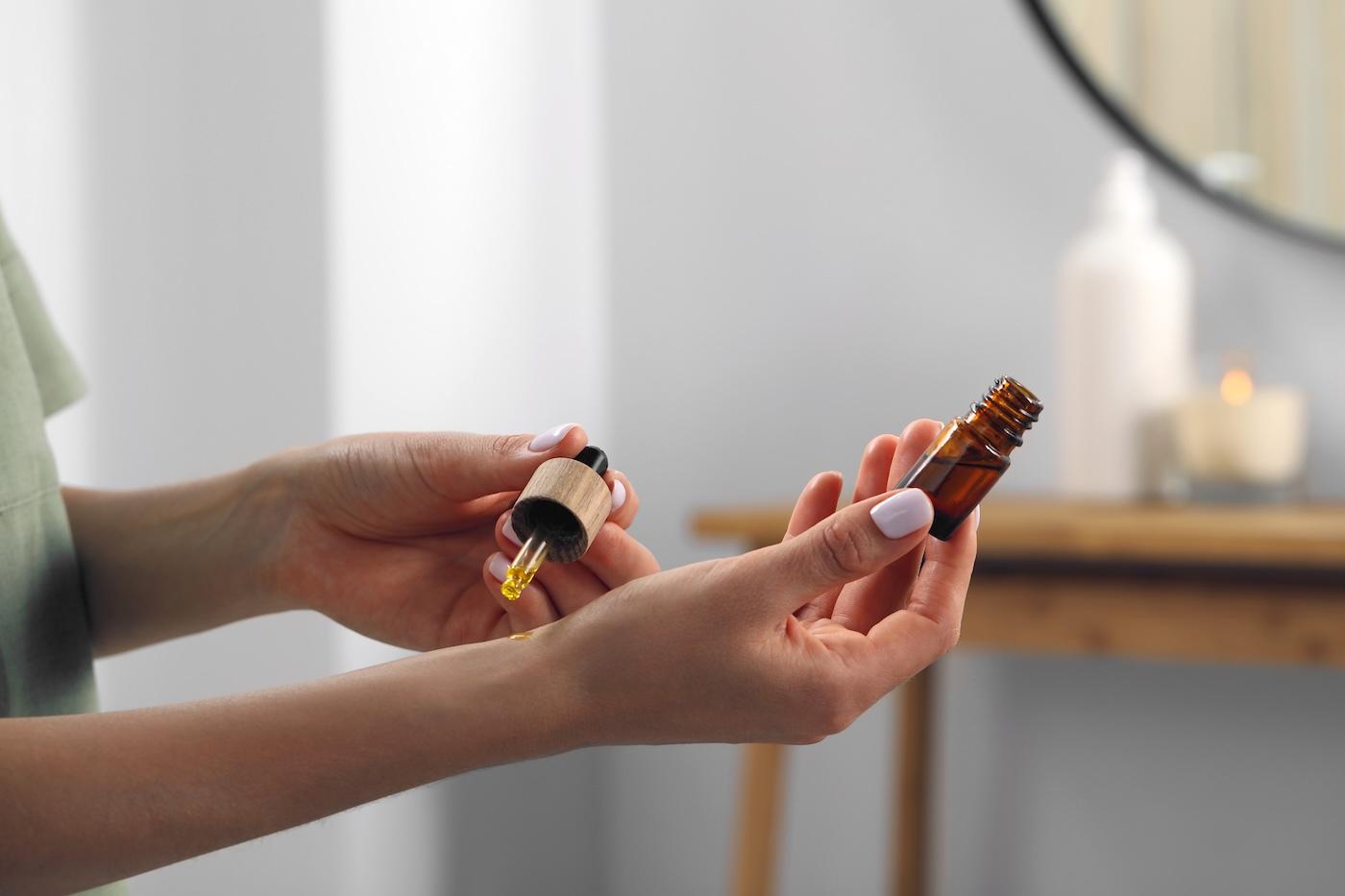 A woman applies an essential oil to her wrist