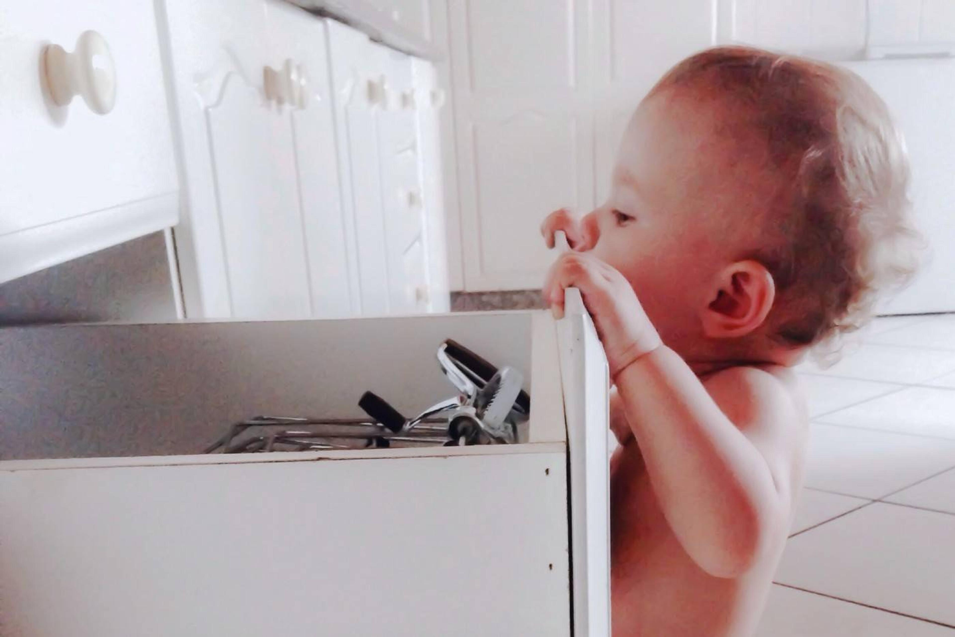 Baby looking inside a kitchen drawer