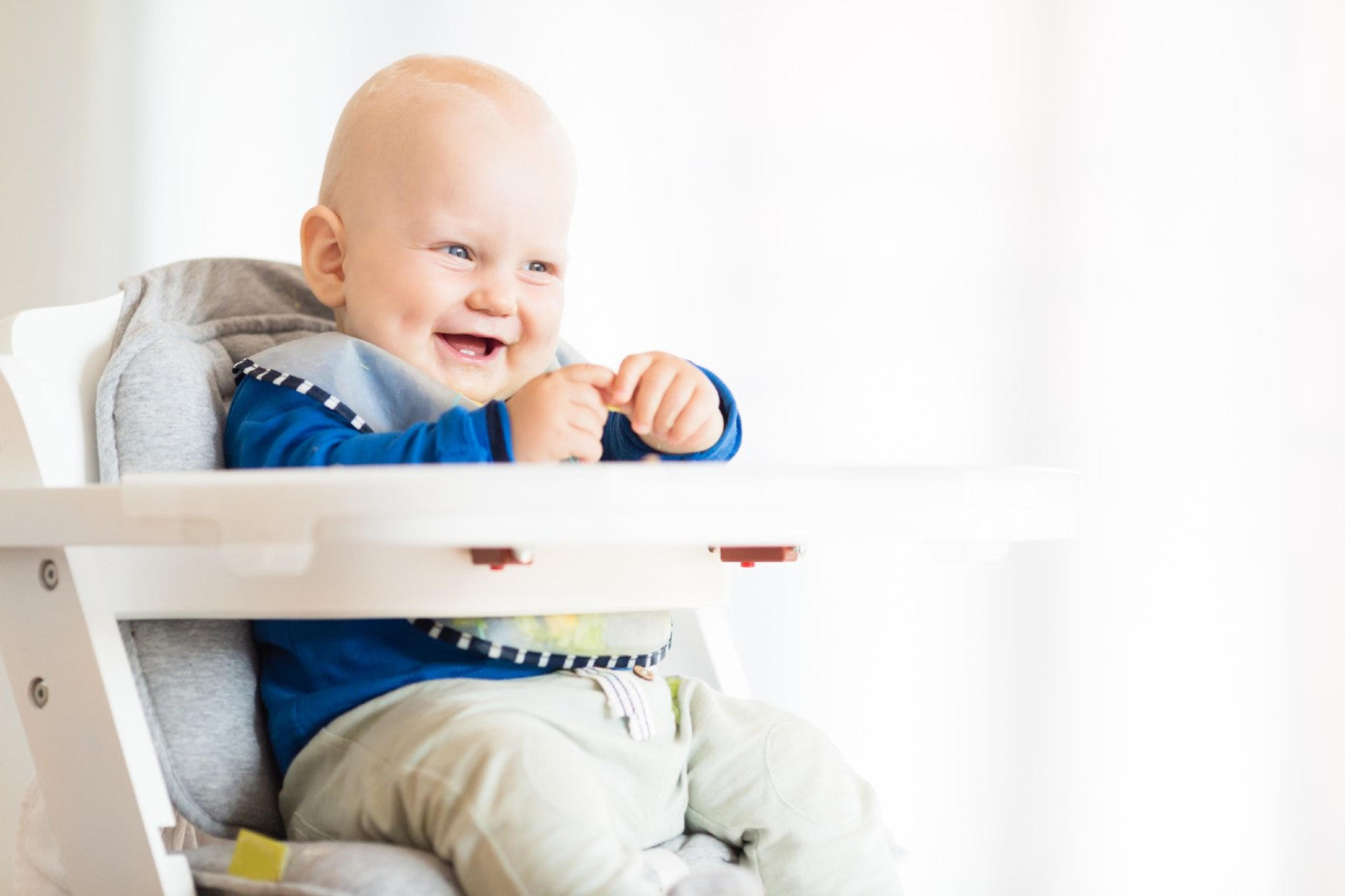 Happy baby eating at a high chair