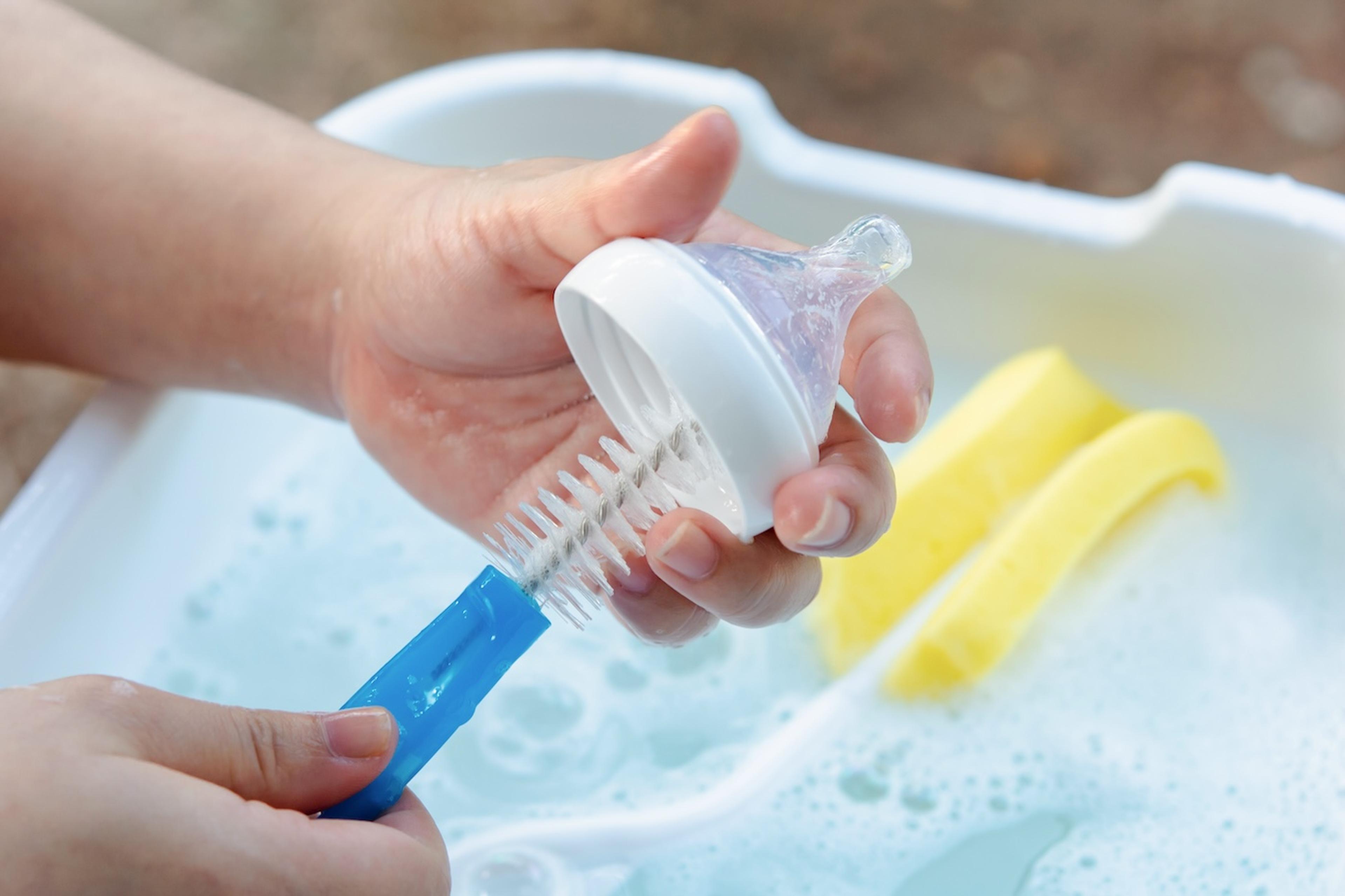 A parent cleans a baby bottle