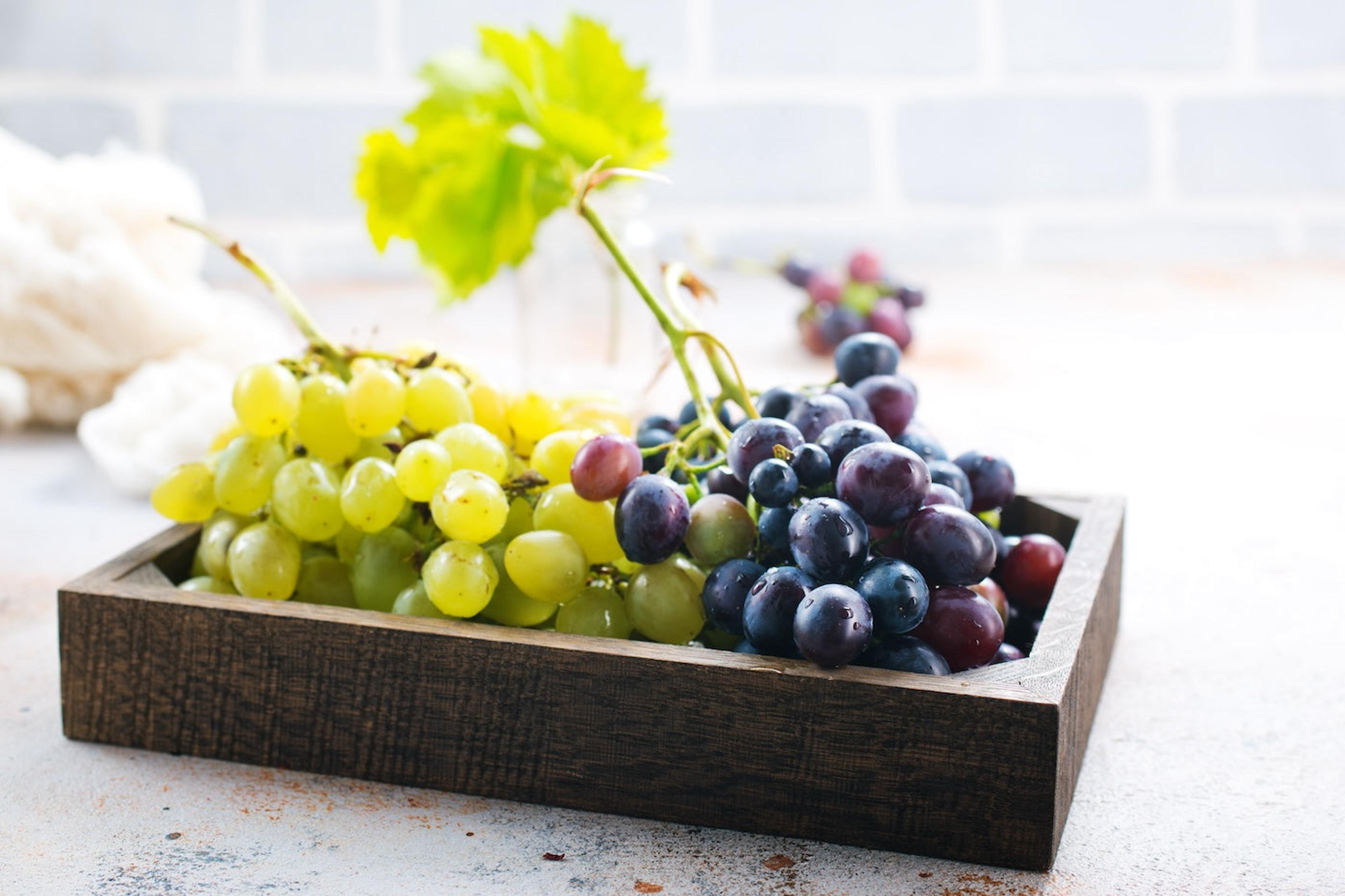 Tray of green and purple grapes