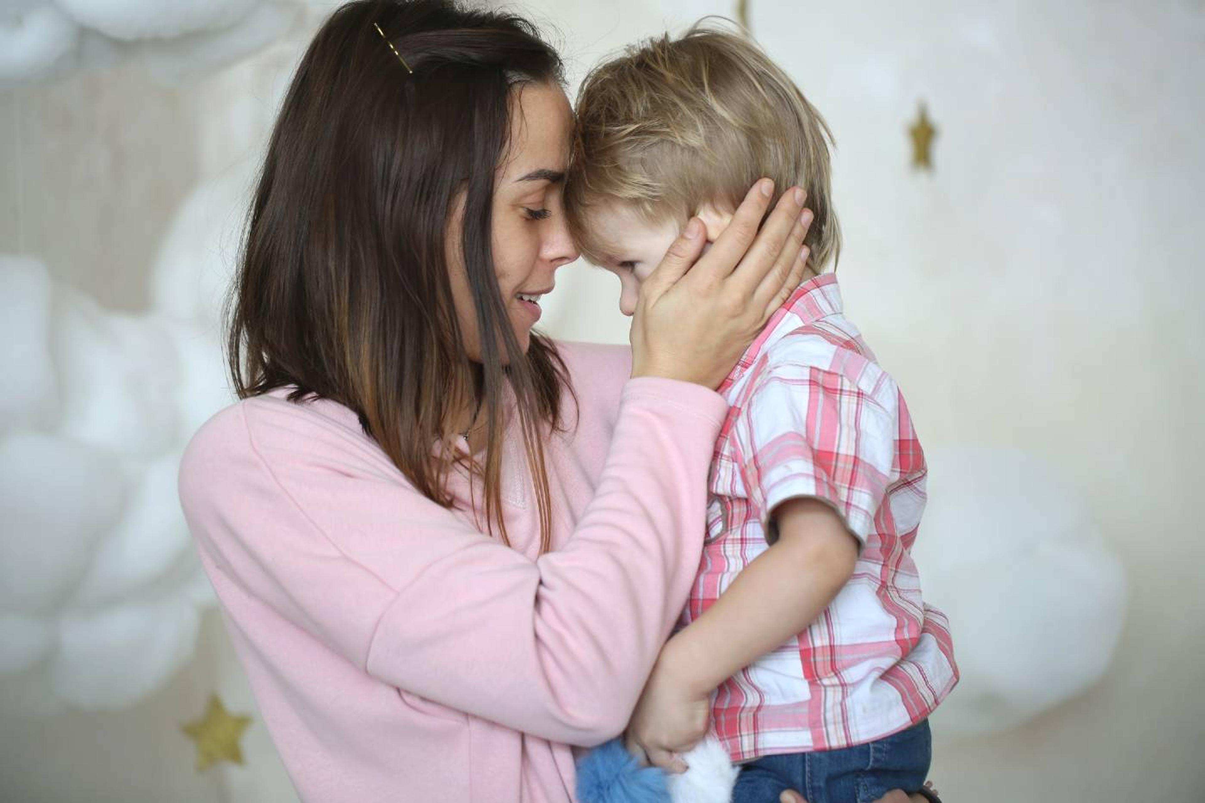 Mother comforts young son.