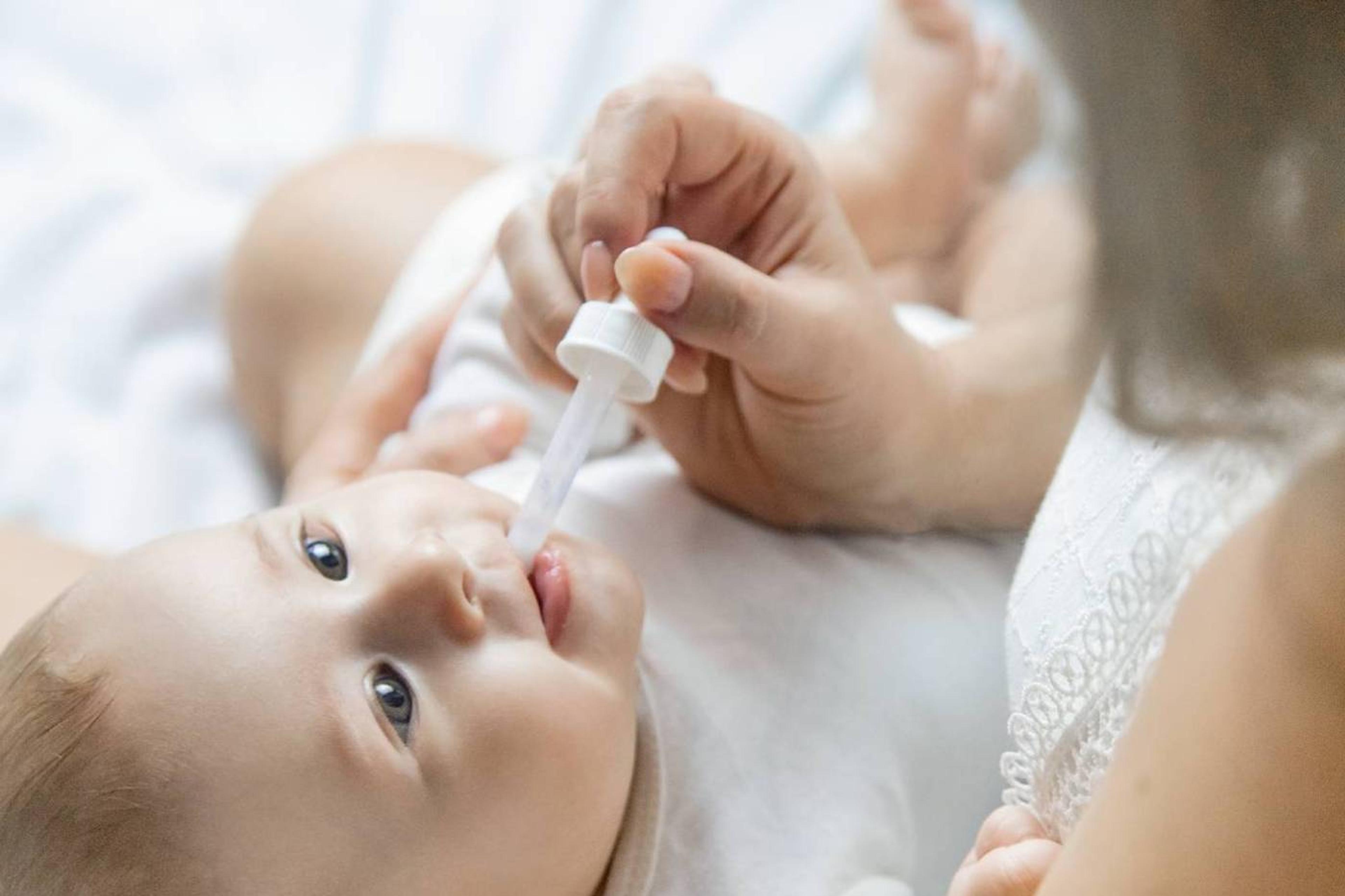 parent giving baby medicine in a dropper