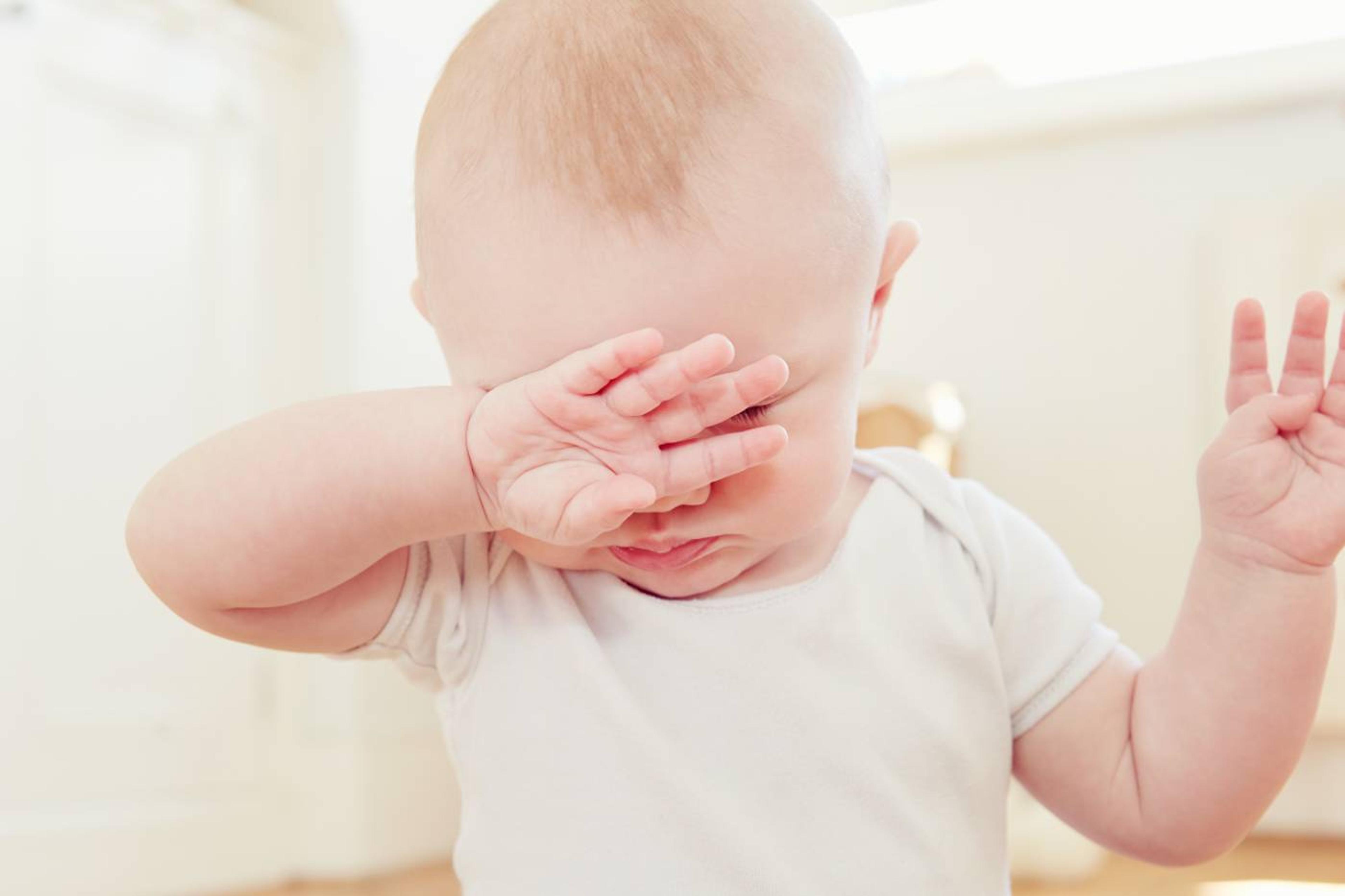 Baby sleep mistakes: tired baby covering face