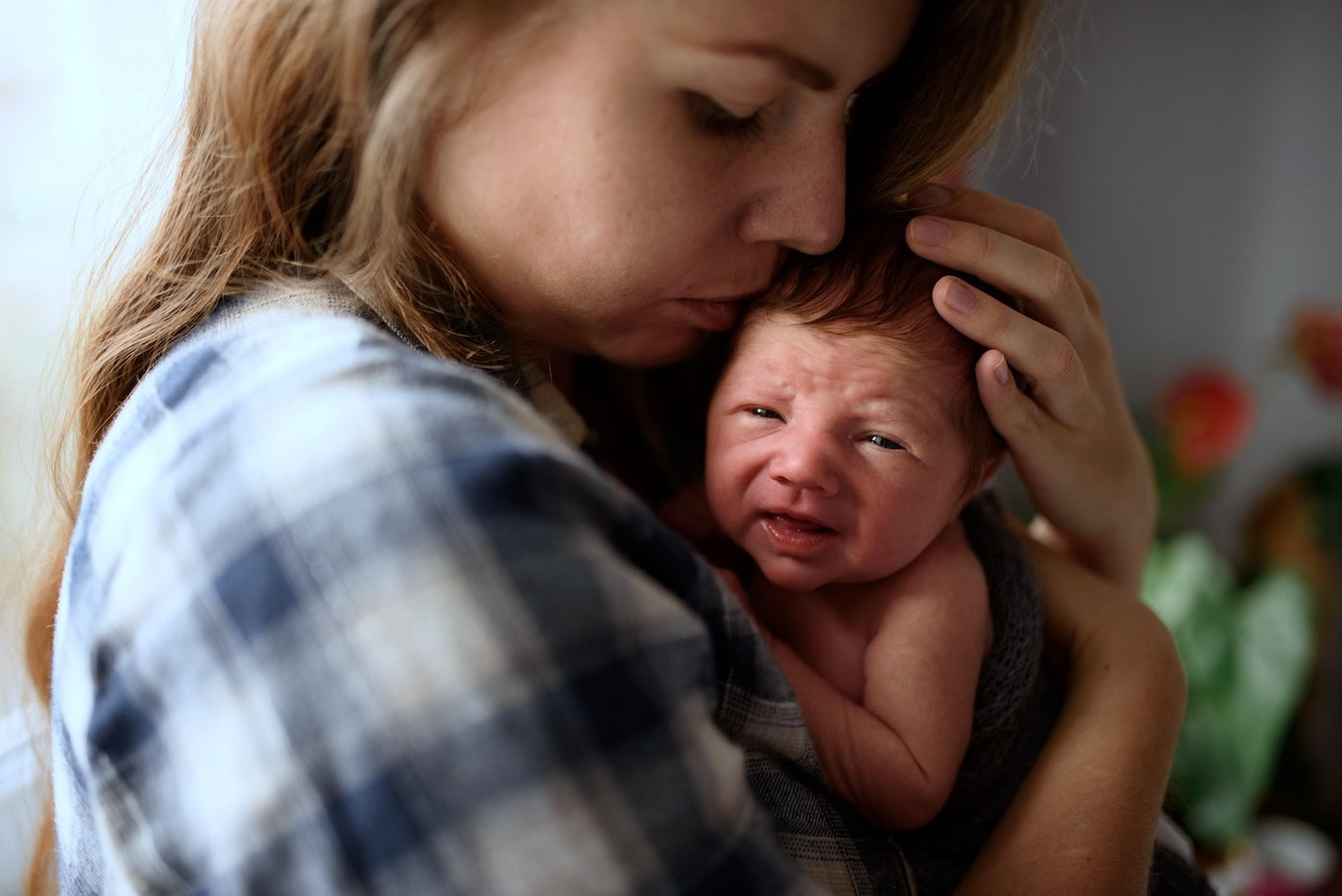A worried mom holds her newborn