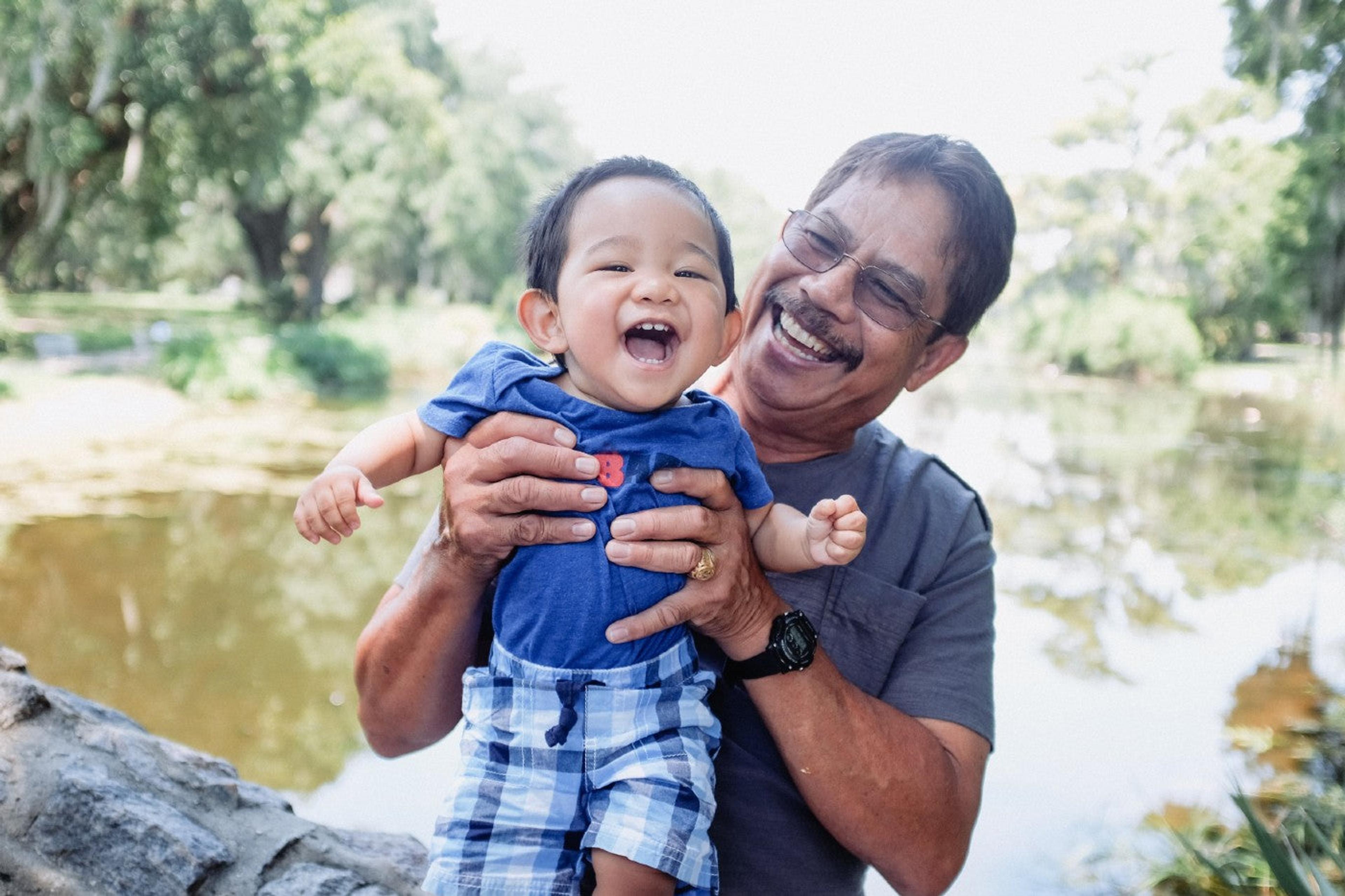 A grandfather holds his toddler grandson