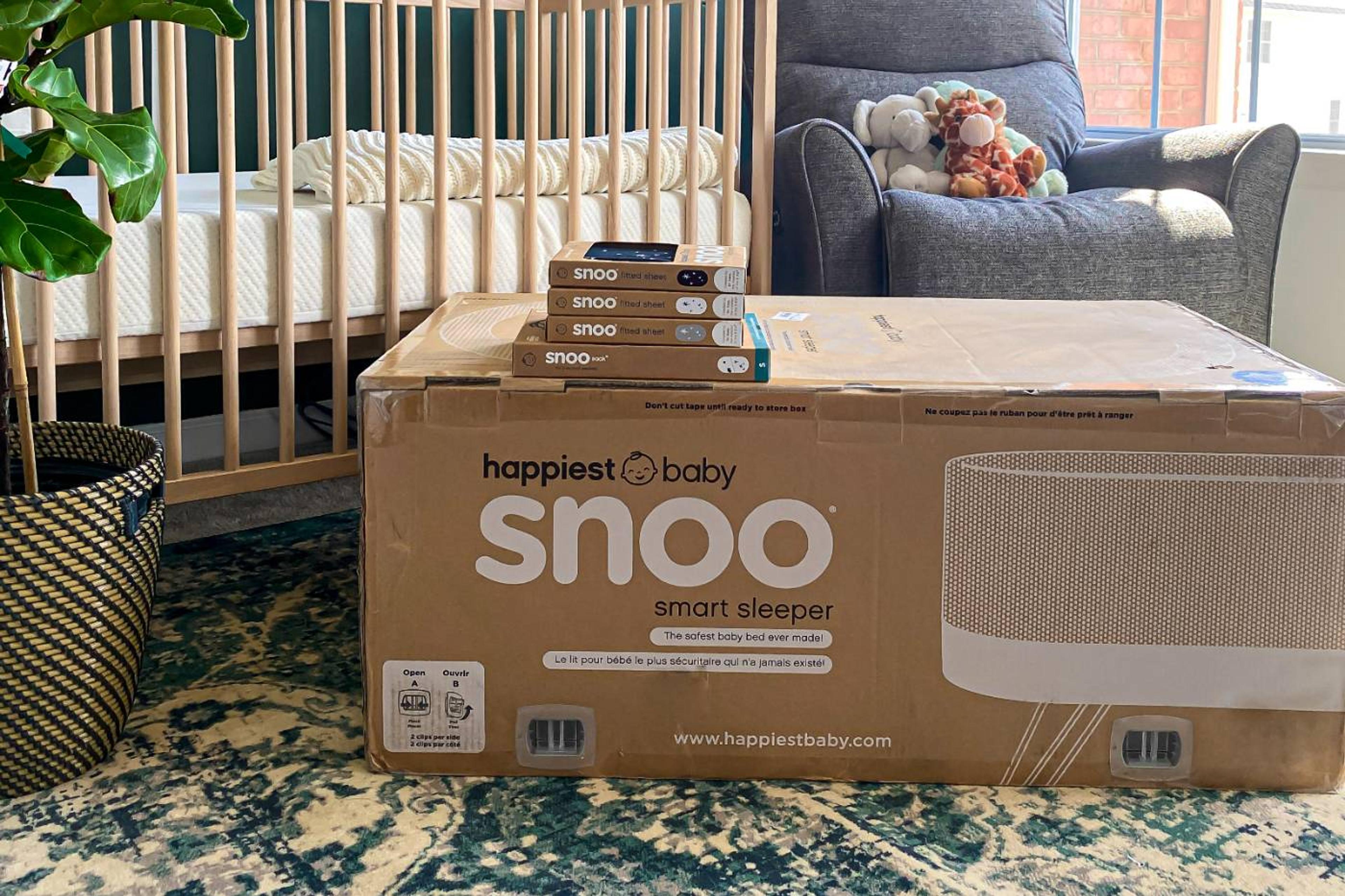 SNOO package and boxed sheets sitting in baby nursery 