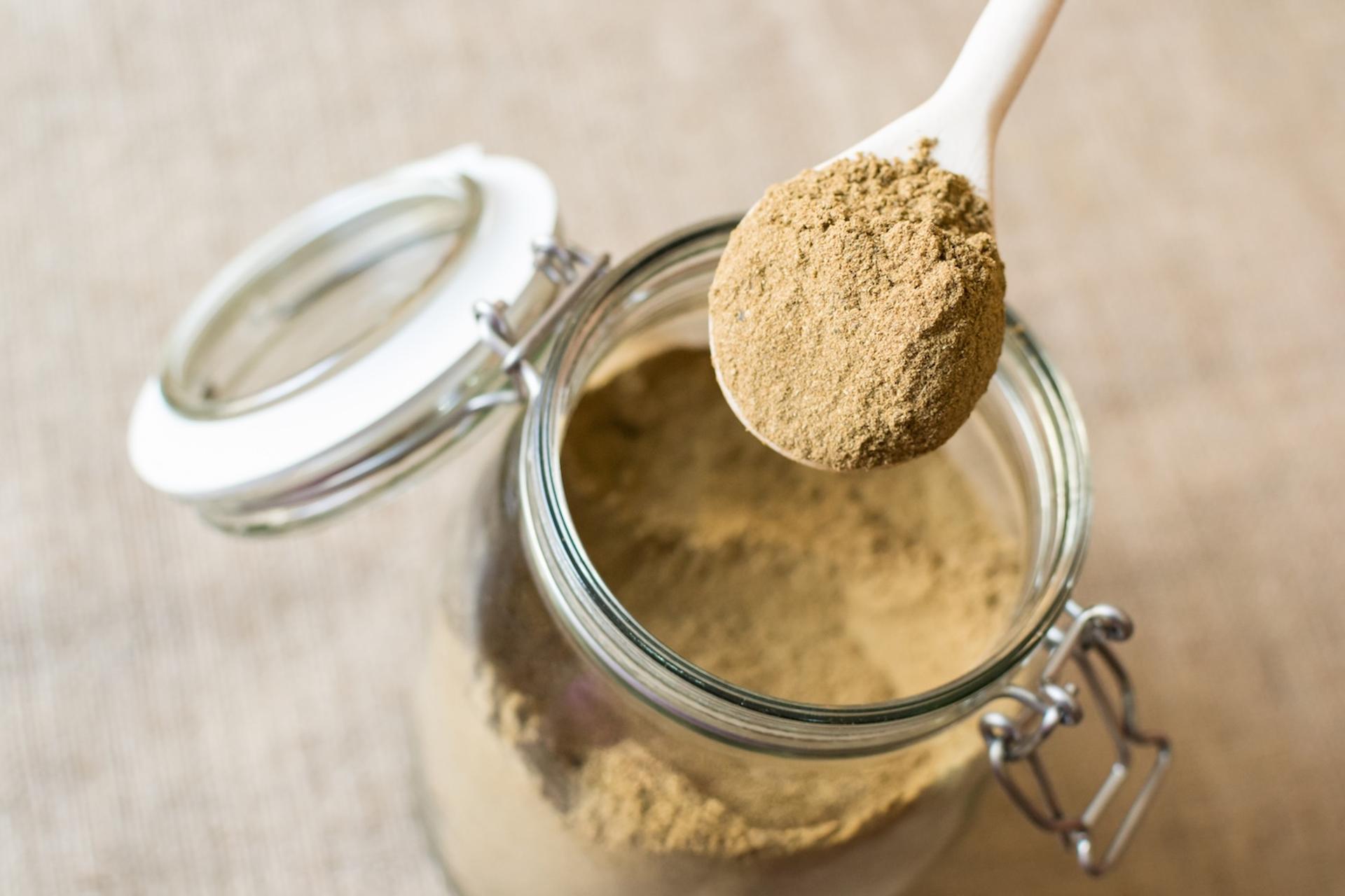 Somone scoops tocos powder out of a jar
