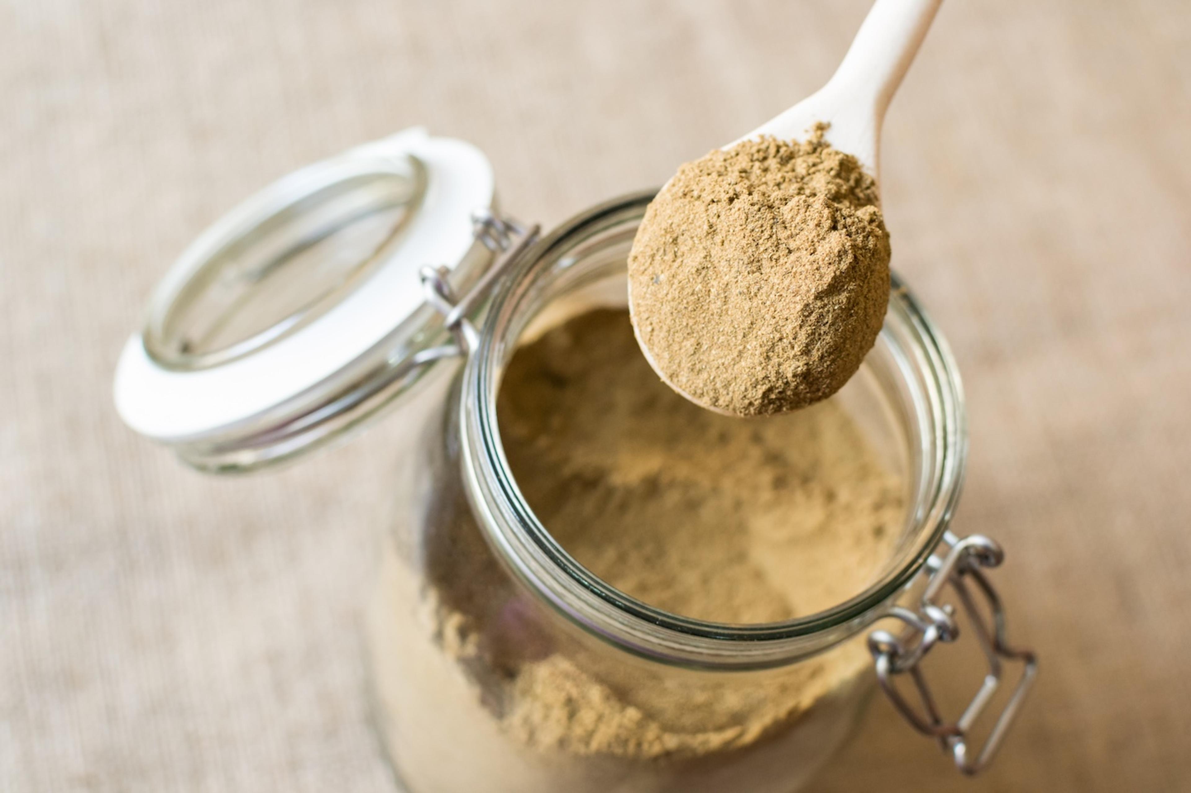 Somone scoops tocos powder out of a jar