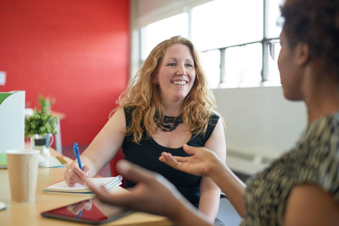 New mom chatting with coworker after returning from parental leave