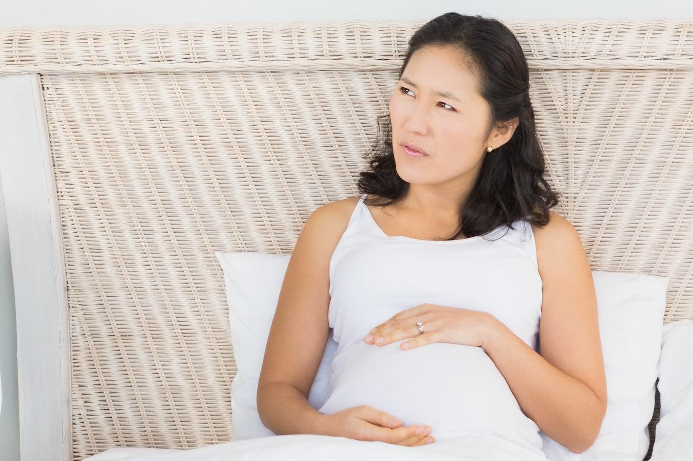 A pregnant woman with a confused look on her face