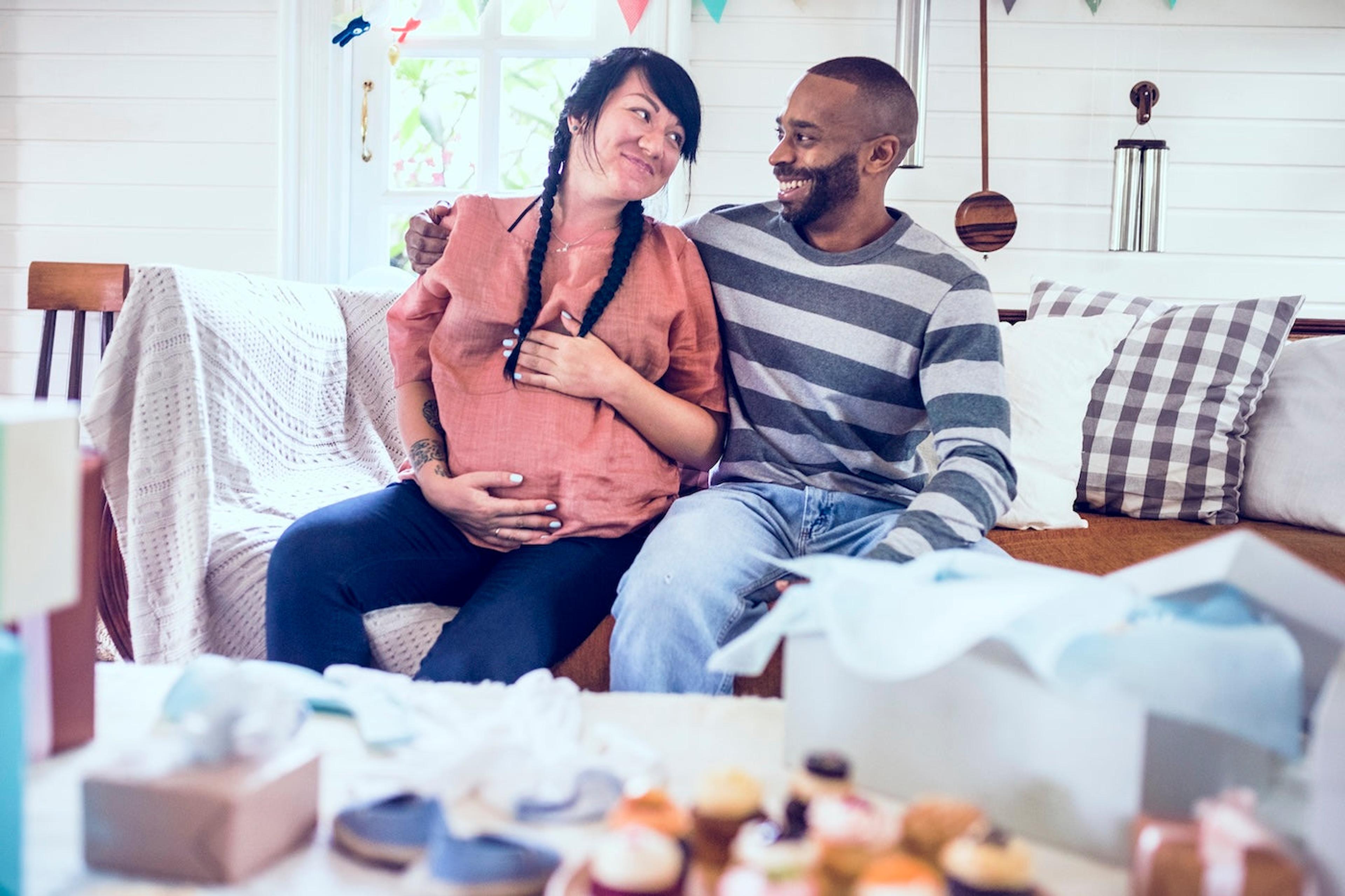 Expectant mother and father sitting on a couch