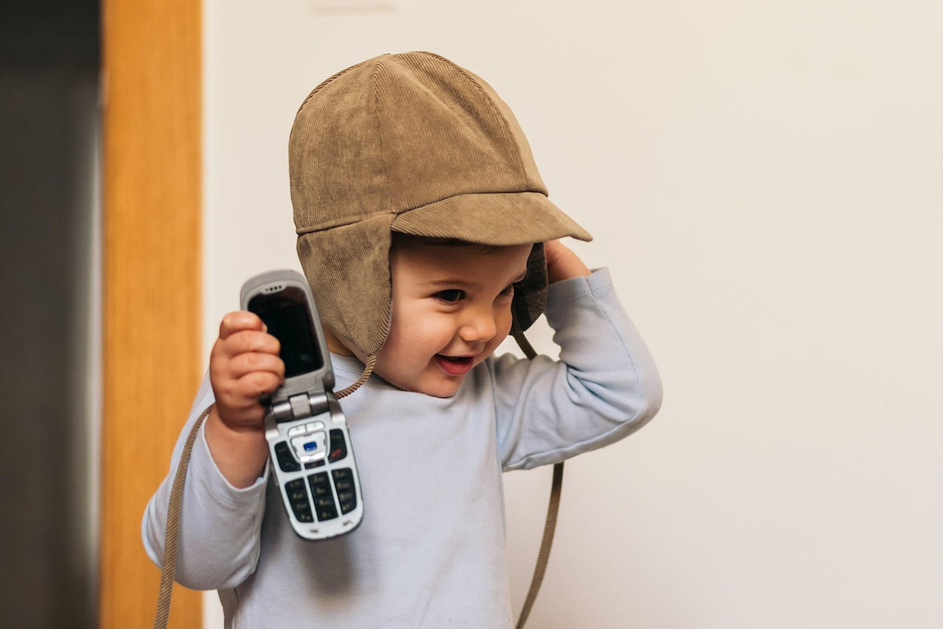 Baby holds 2000s style flip phone