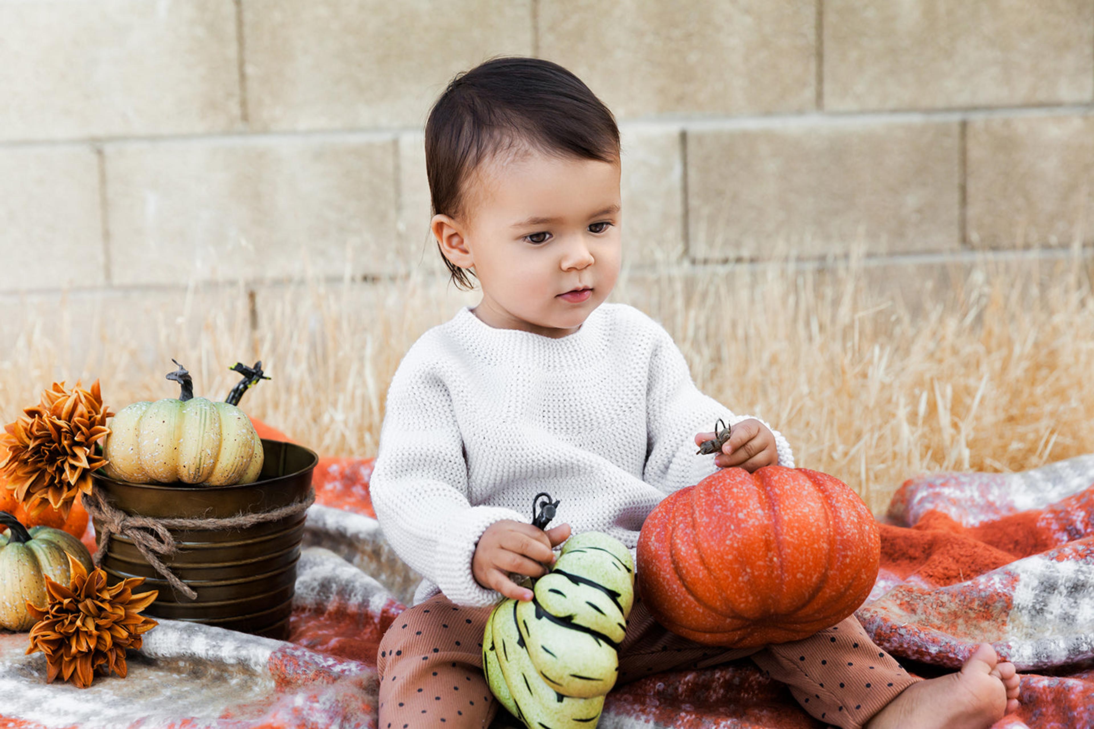 November babies: Baby sitting with pumpkins