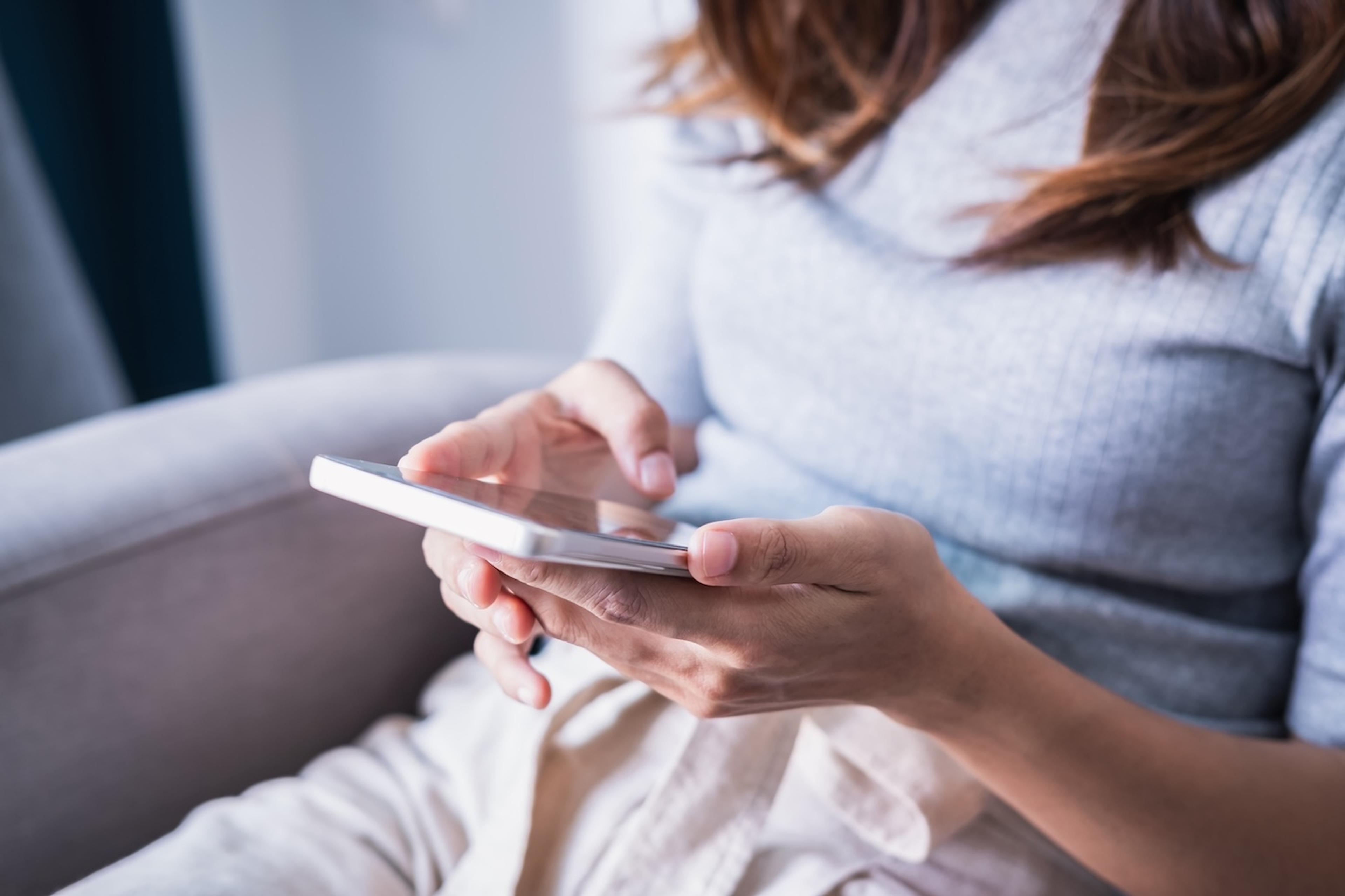 A mom looks down at a smartphone