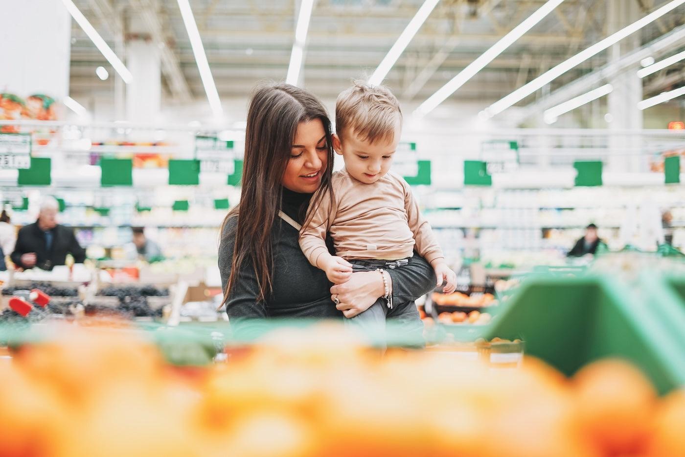 A mom shops for groceries with her toddler