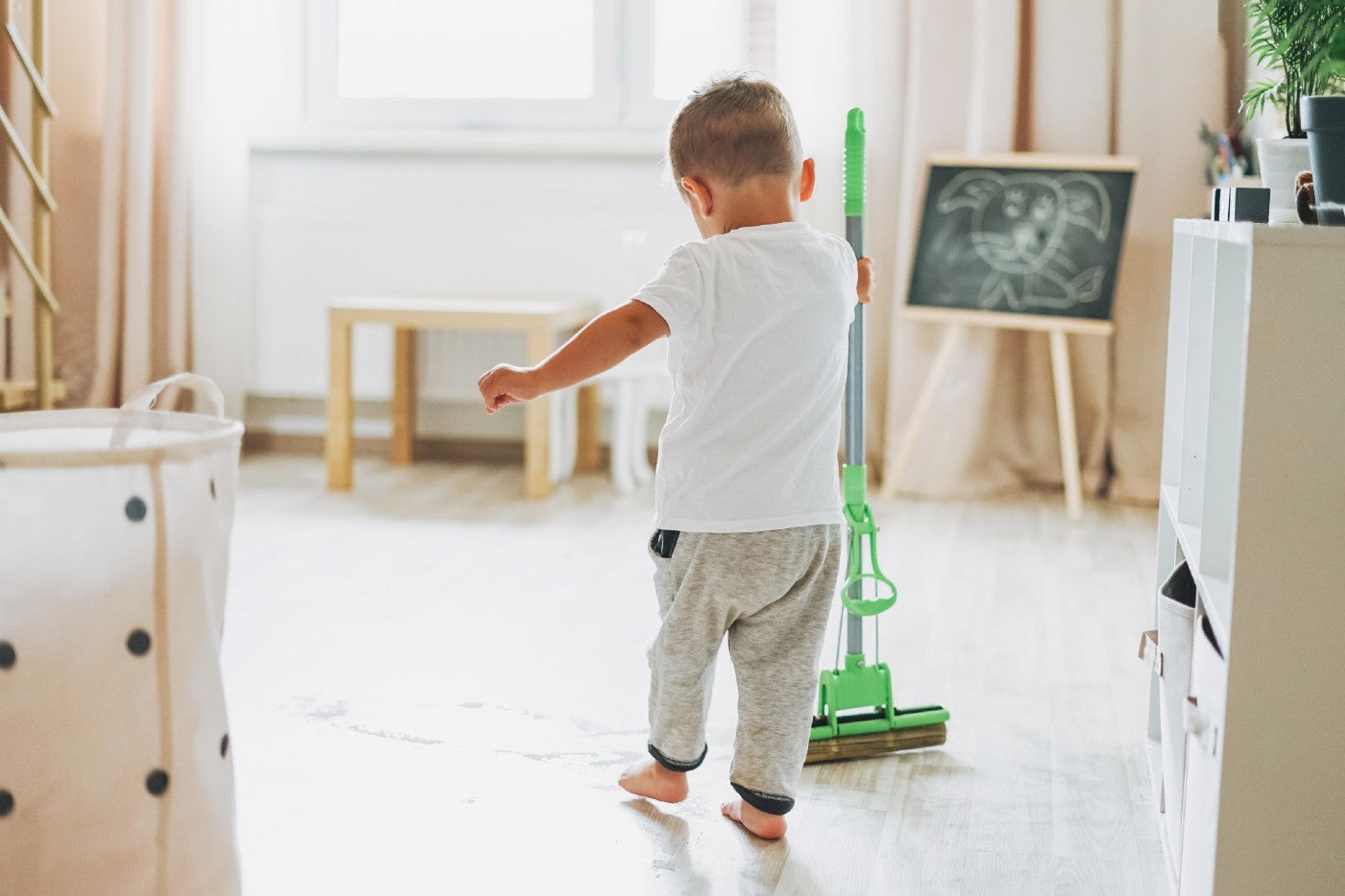 A little boy mops a children's room