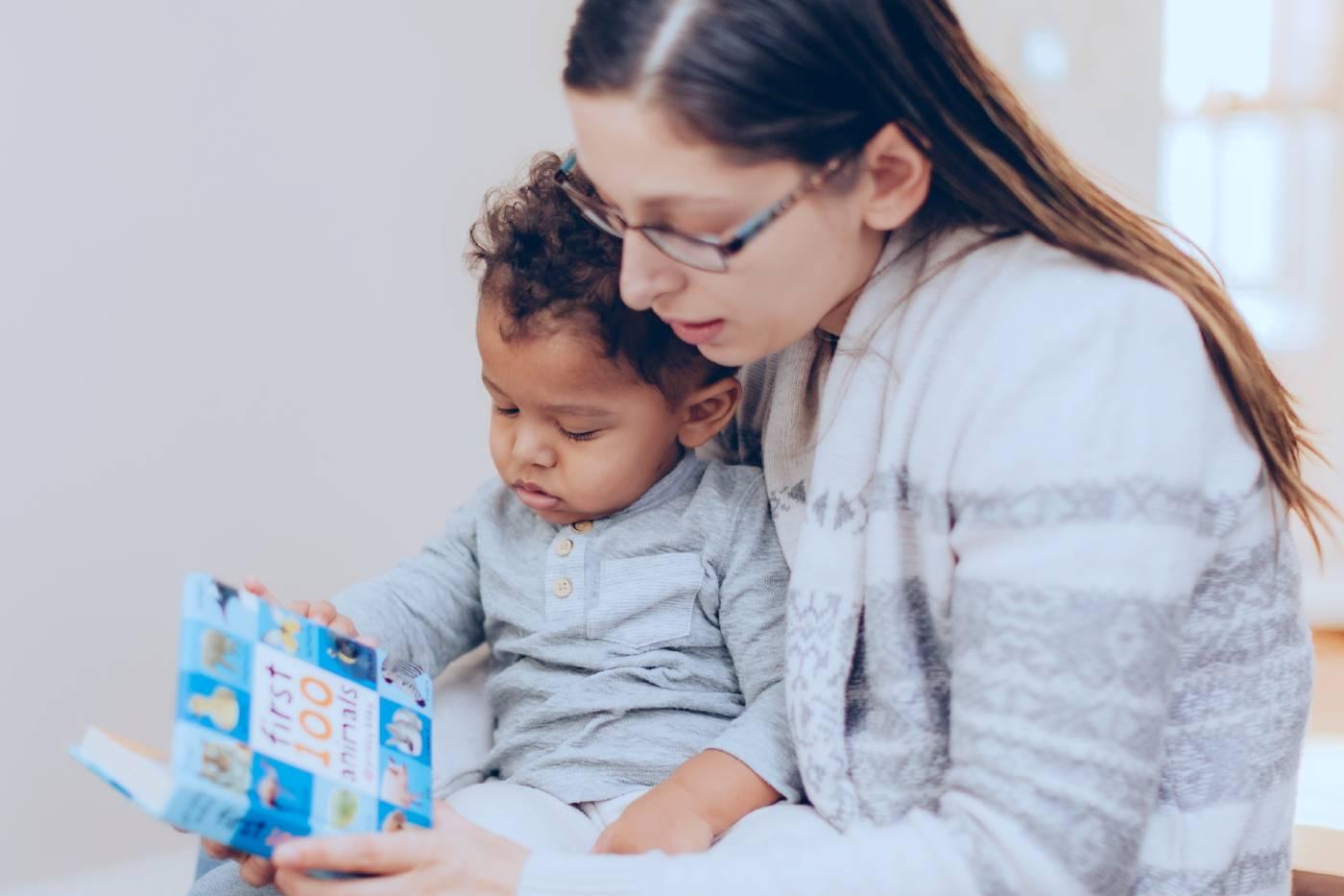 mom reading book to her baby