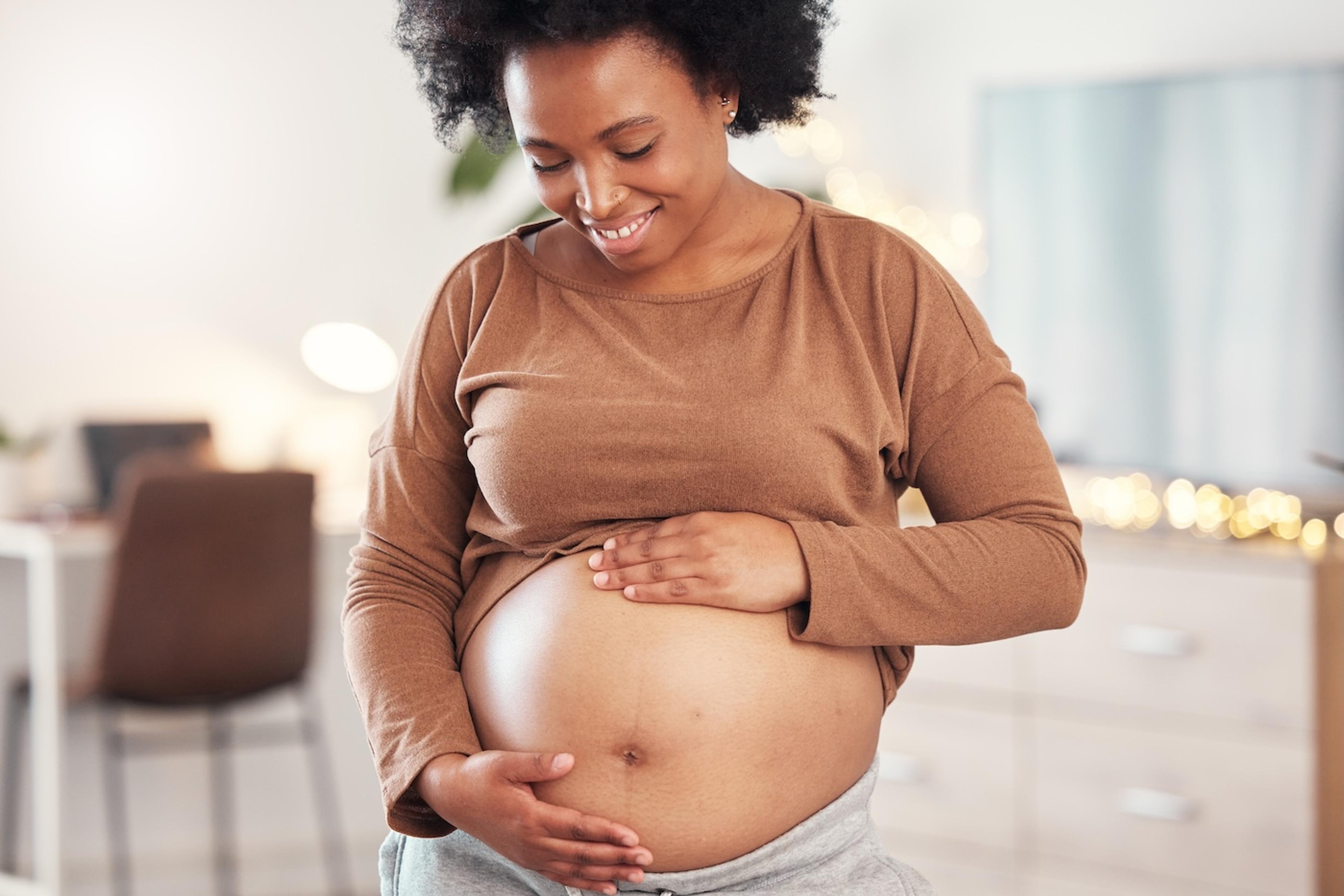 A pregnant woman looks at her belly