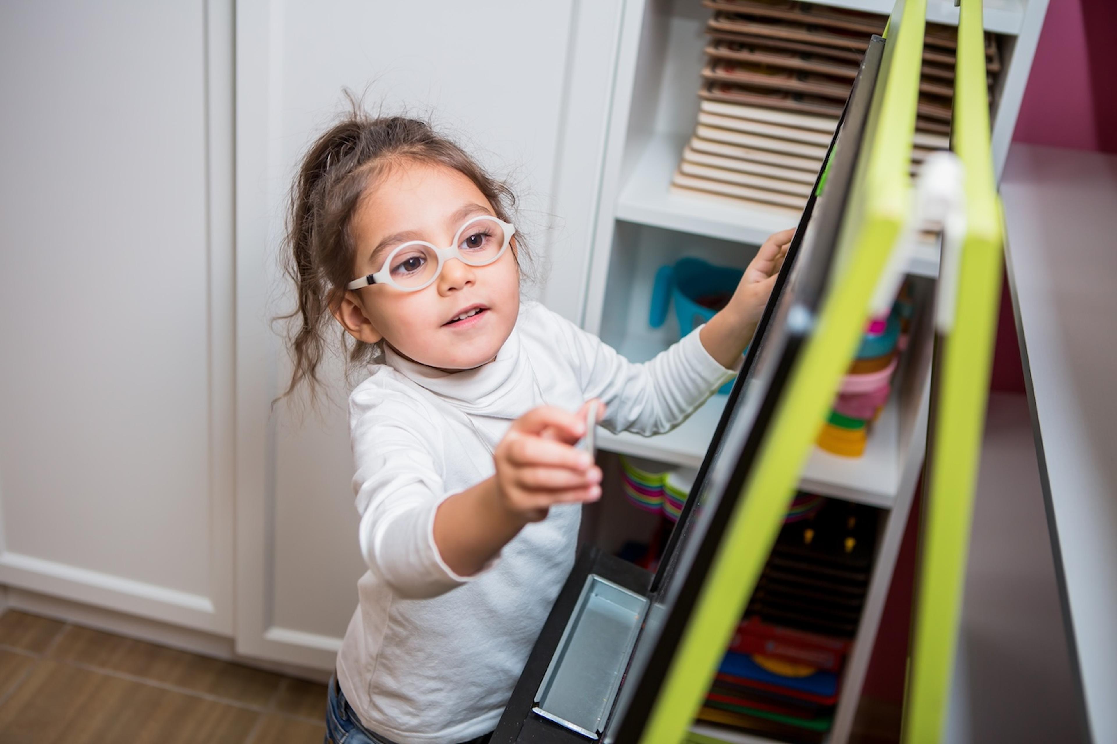 A toddler places an item on a daily routine chart
