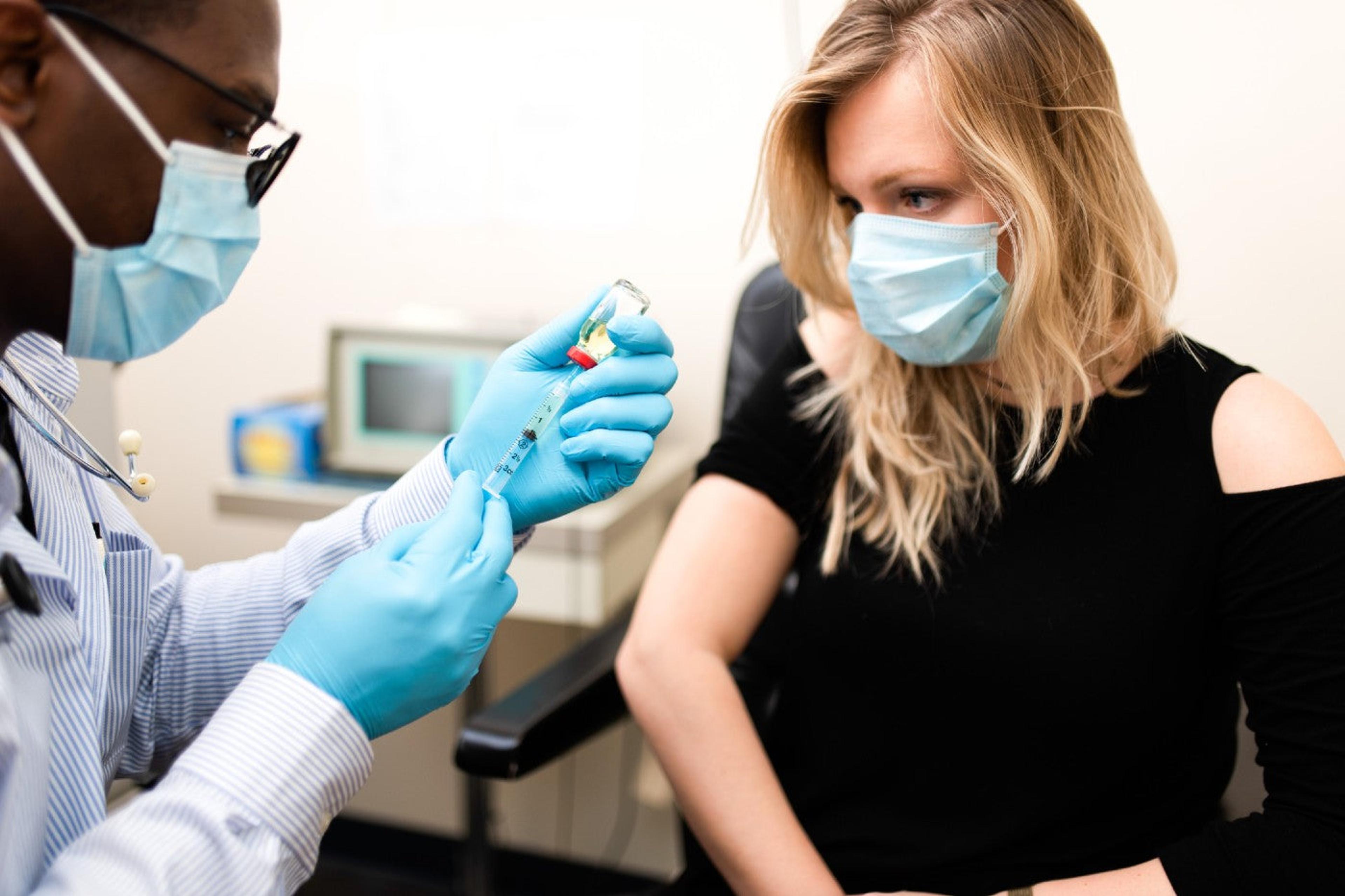 COVID vaccine - woman receiving COVID vaccine from doctor