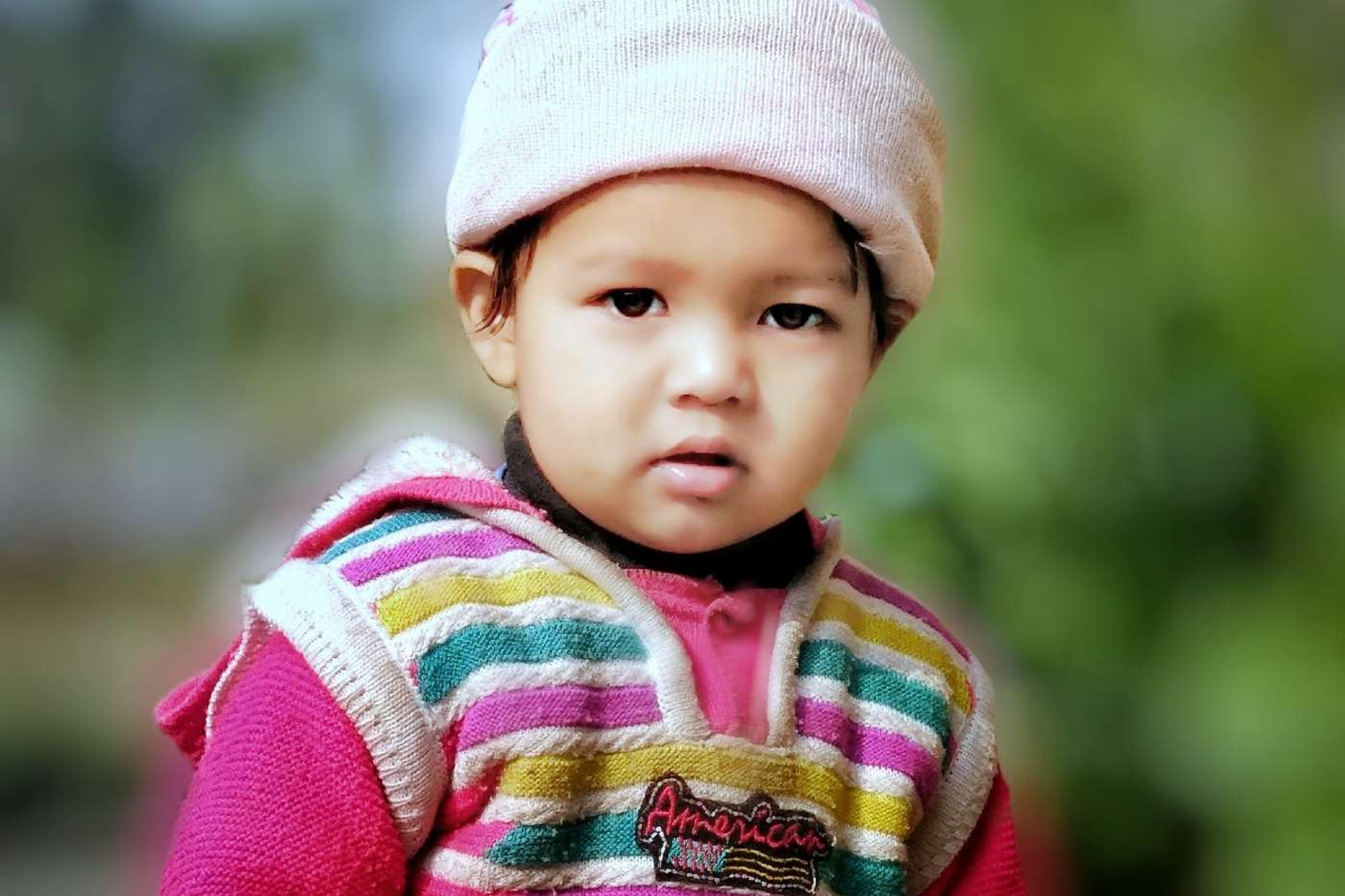 Native American baby names - indigenous girl wearing hat and vest