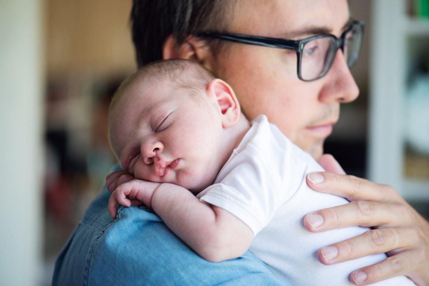Postpartum Depression in Dads: dad holding newborn