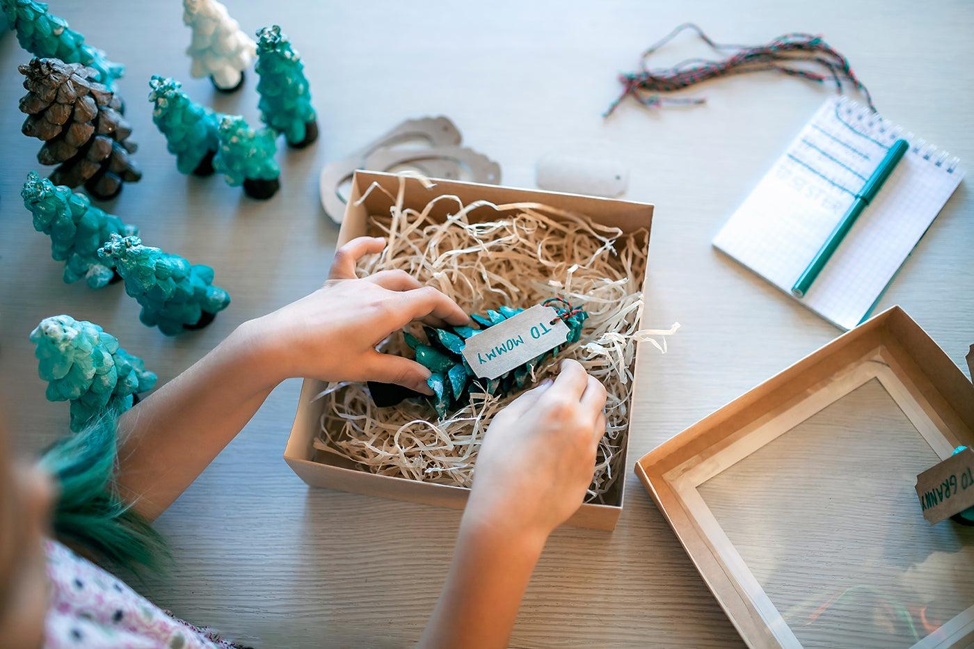A child wraps a homemade holiday gift
